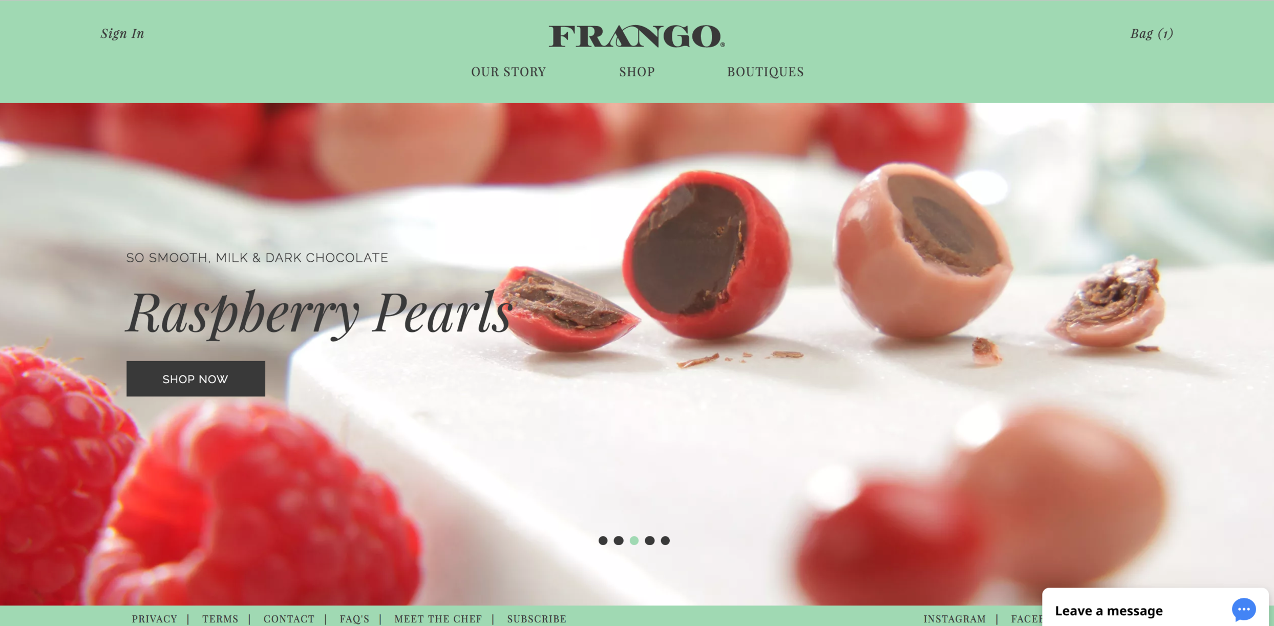 Raspberry pearls chocolate with a soft filling, surrounded by fresh raspberries, on a website with "shop now" button and Frango branding.