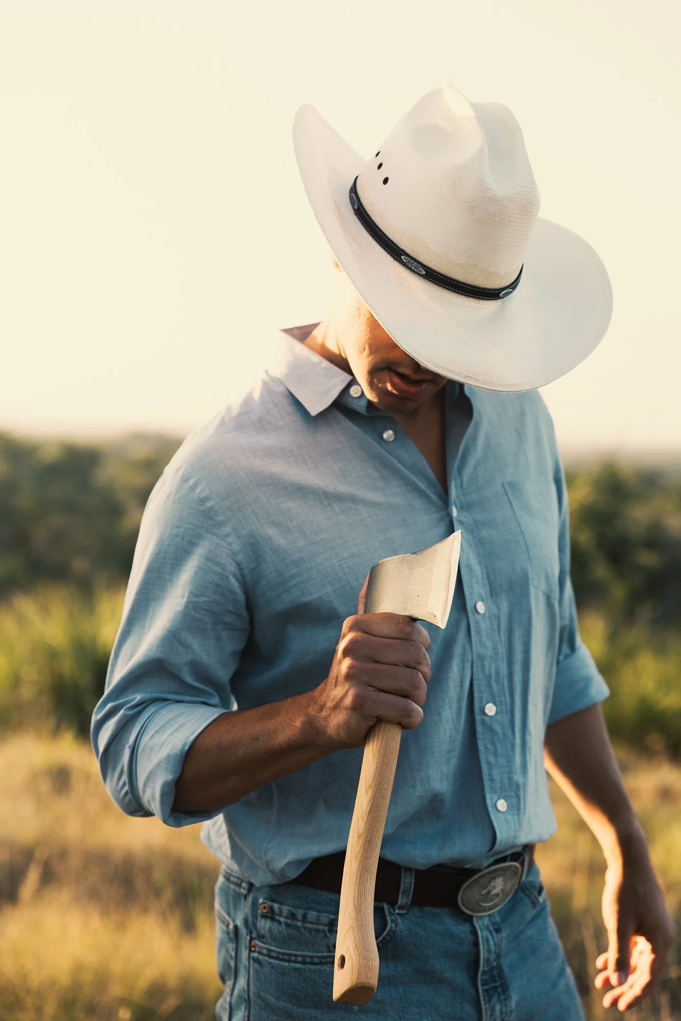 French Fox Design: Desert Door Texas Sotol, Lifestyle Photography: Man in Cowboy Hat Holding Hatchet