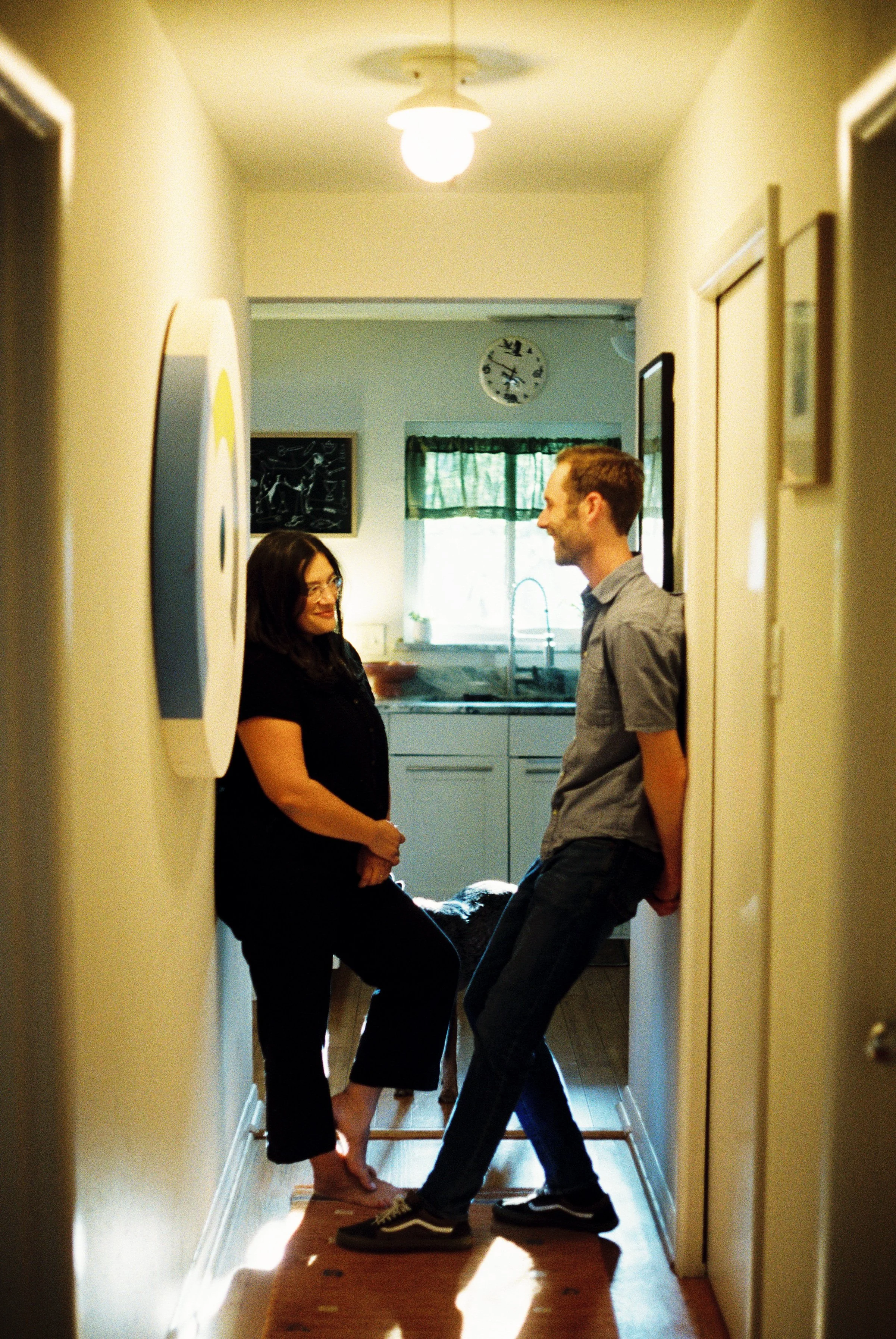 Couple at home in Fort Worth with dogs standing in the hallway, shot on 35mm film