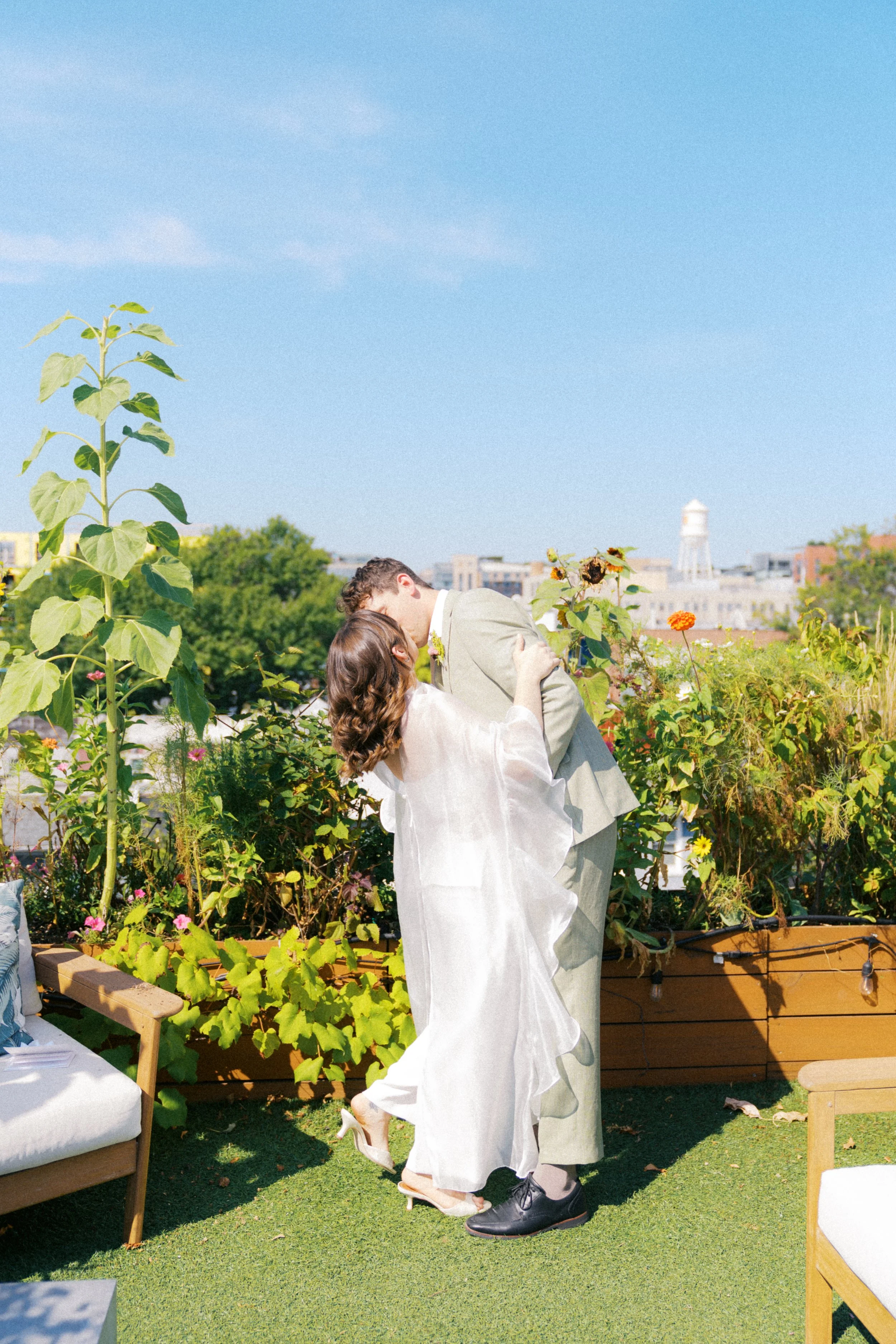 Couple kissing during elopement ceremony in a rooftop garden in Washington, DC