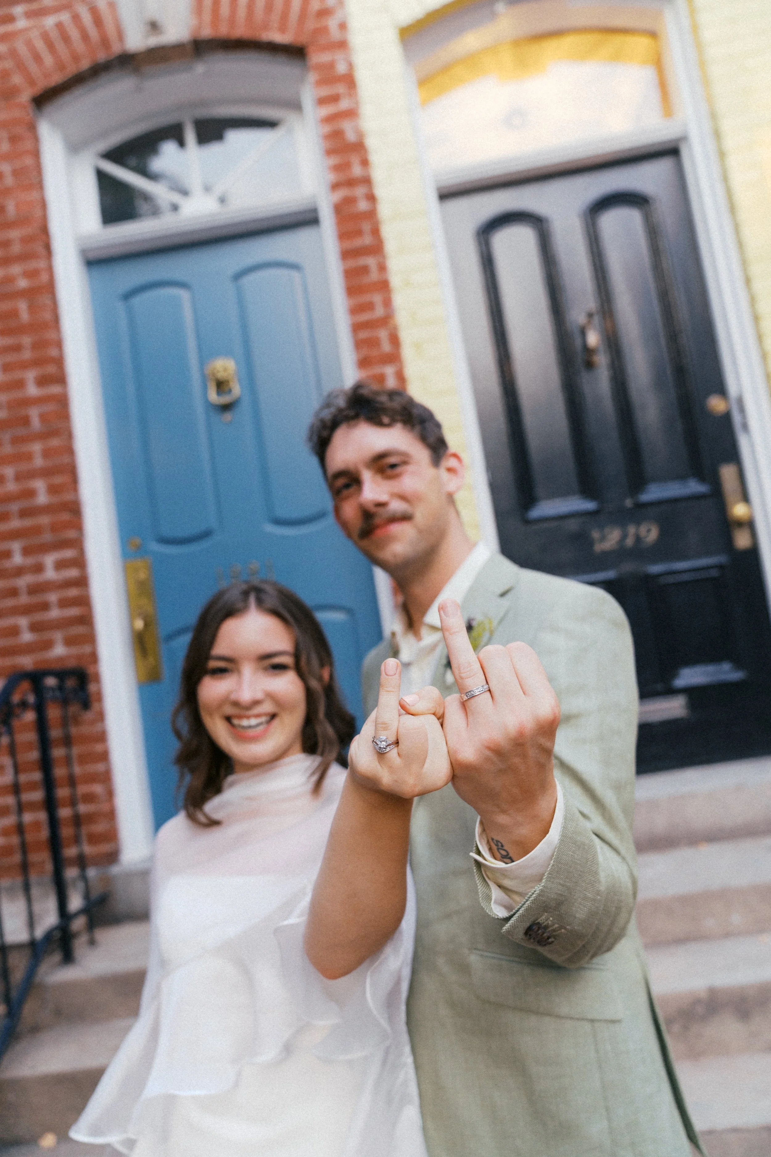  playful newly married couple portrait in front of colorful georgetown row house doors 
