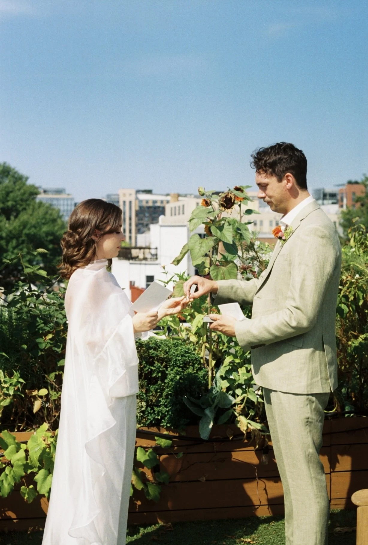 Couple exchanging rings during elopement on rooftop in Washington DC, shot on 35mm film