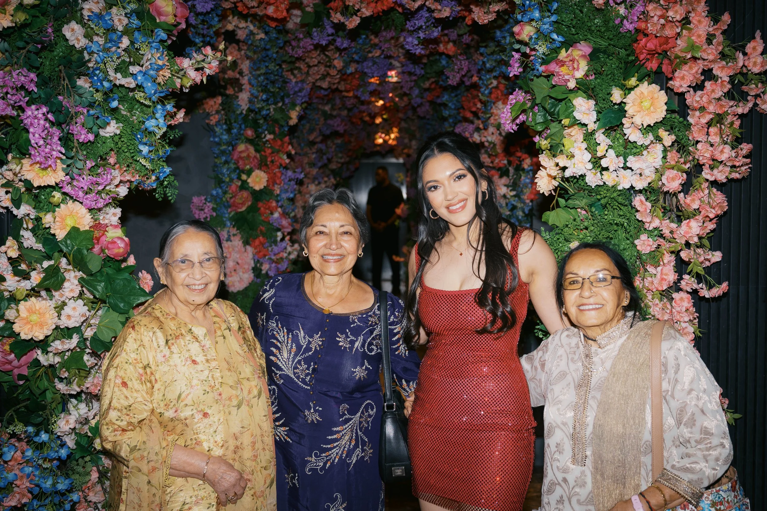 family portrait under floral wall at Catbird Dallas birthday celebration