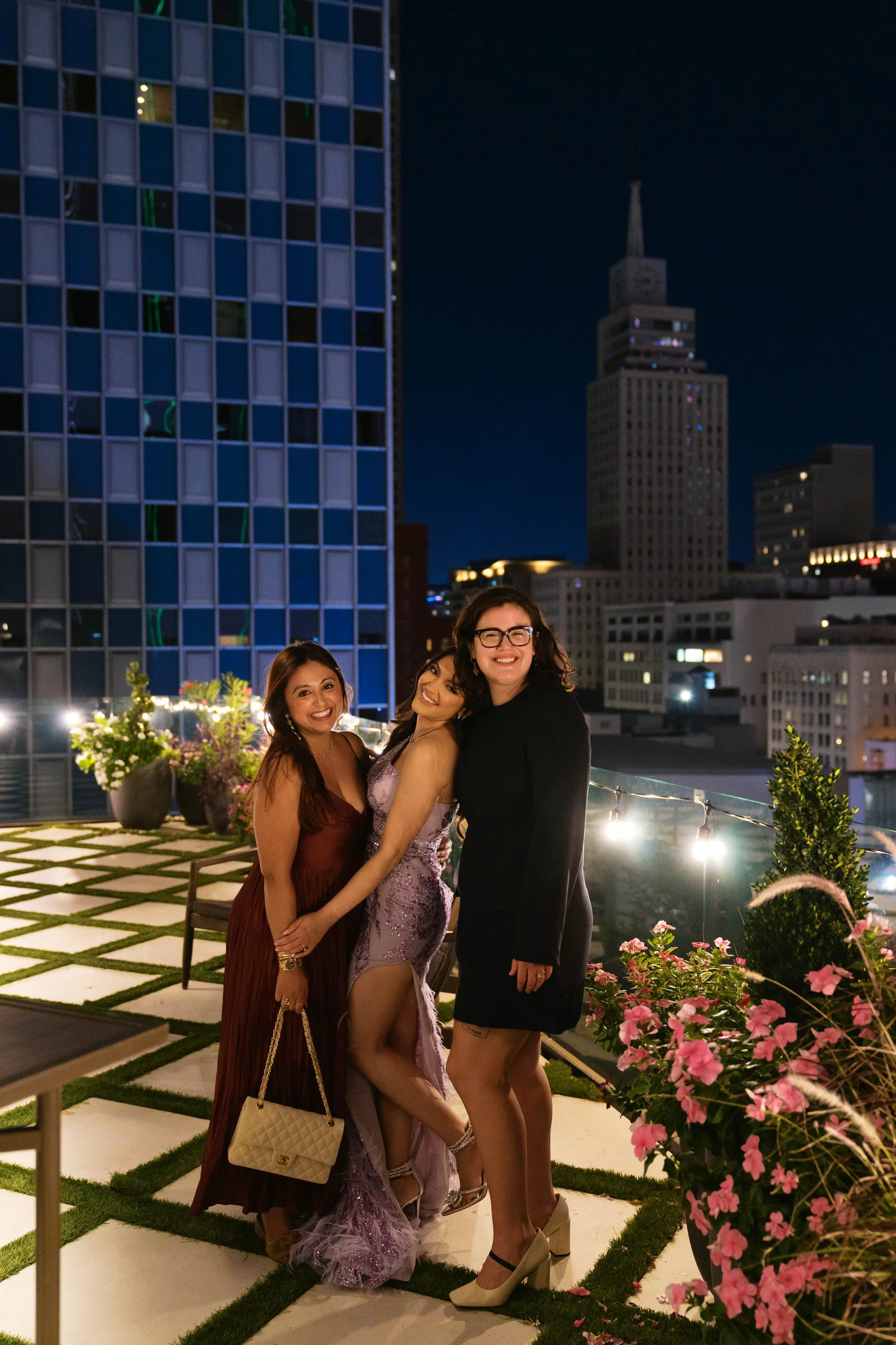 friends posing on Catbird Dallas rooftop at night