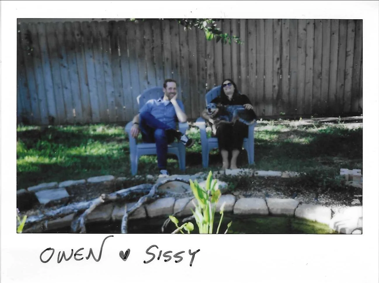 Couple sitting outside in backyard with dog on lap, shot on instax wide