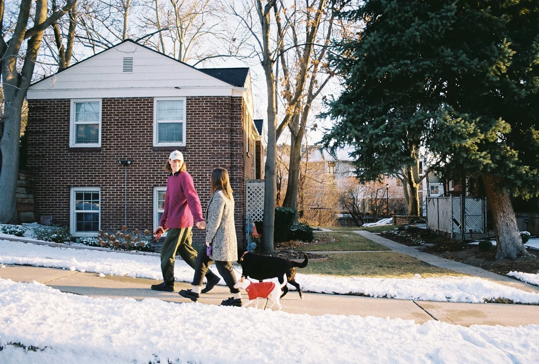 Couple walking dogs outside on a snowy day in Salt Lake City, Utah, shot on 35mm film