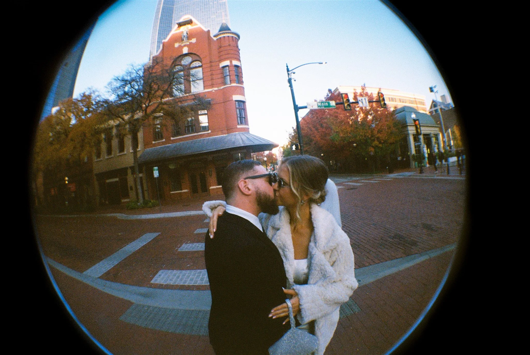 Couple kissing in Sundance Square Fort Worth photographed with fisheye lens