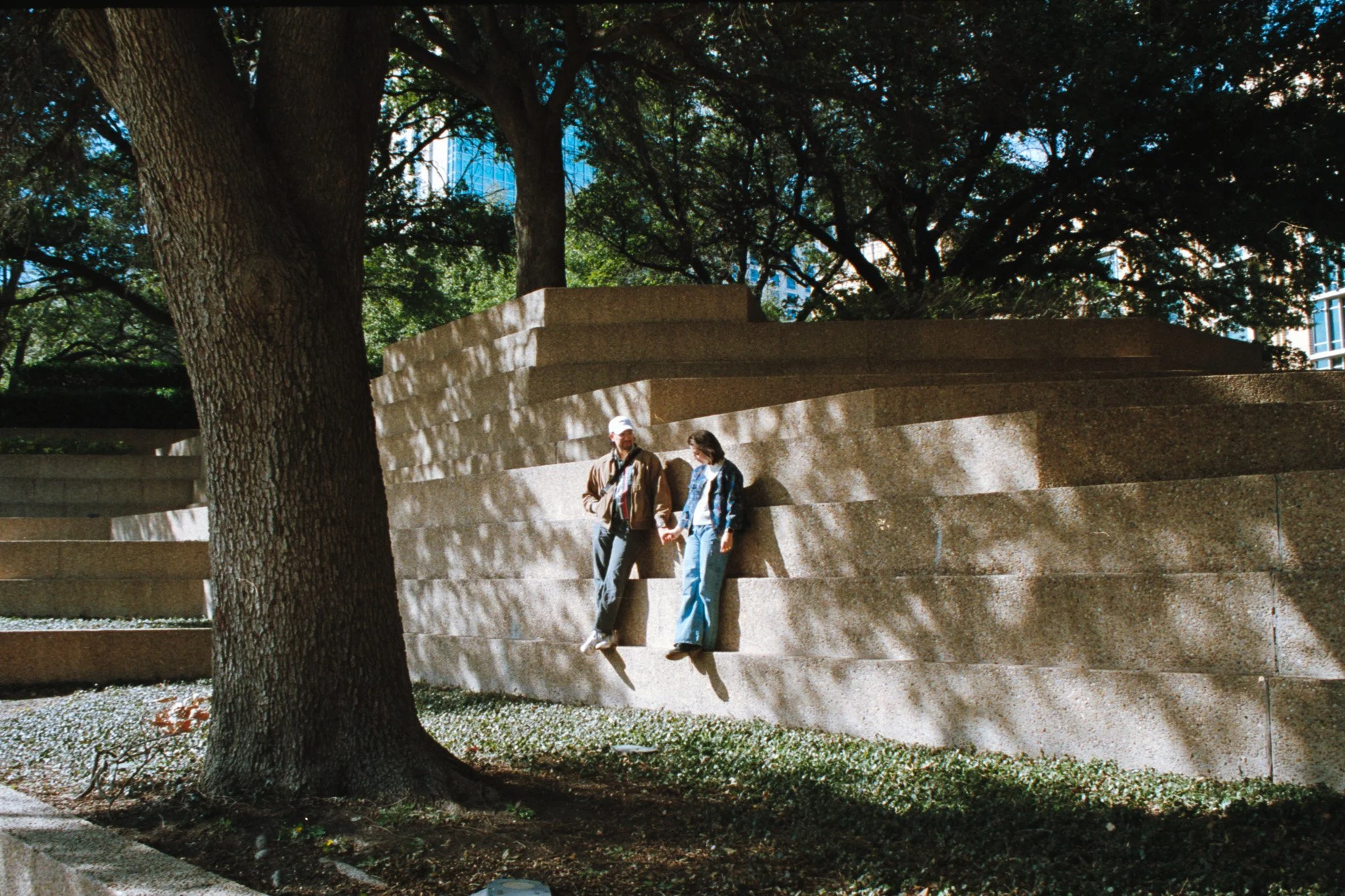 couple holding hands while standing on steps at Fort Worth Water Gardens, shot on 35mm film