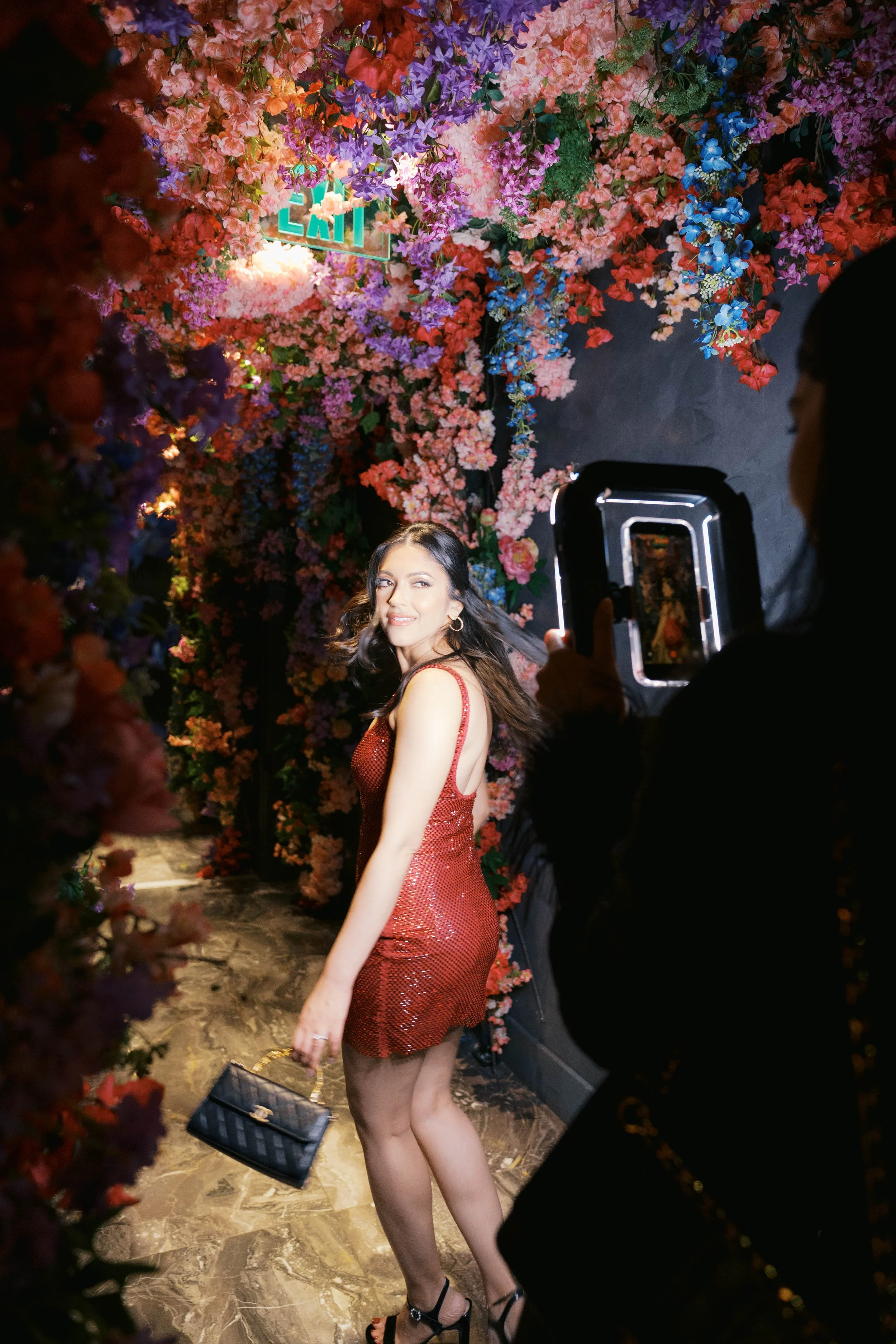 Birthday girl posing under floral wall at Catbird Dallas birthday party