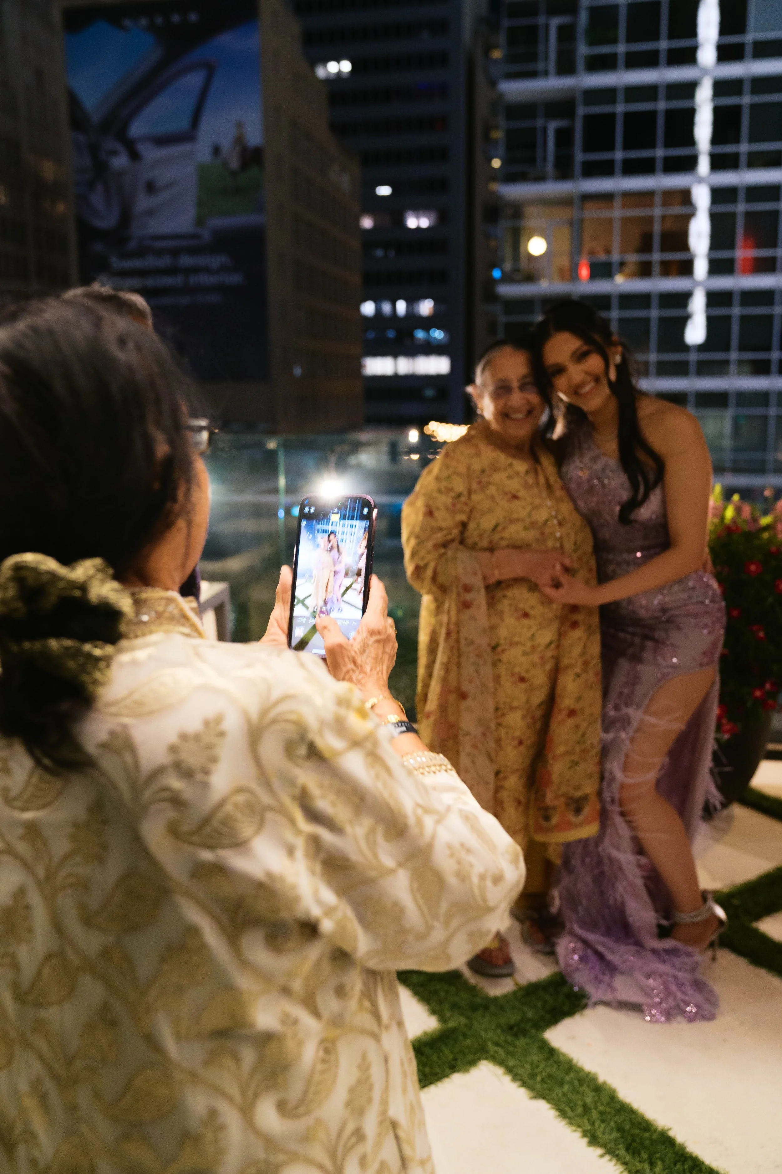 grandmother taking photo on phone at Catbird Dallas birthday party