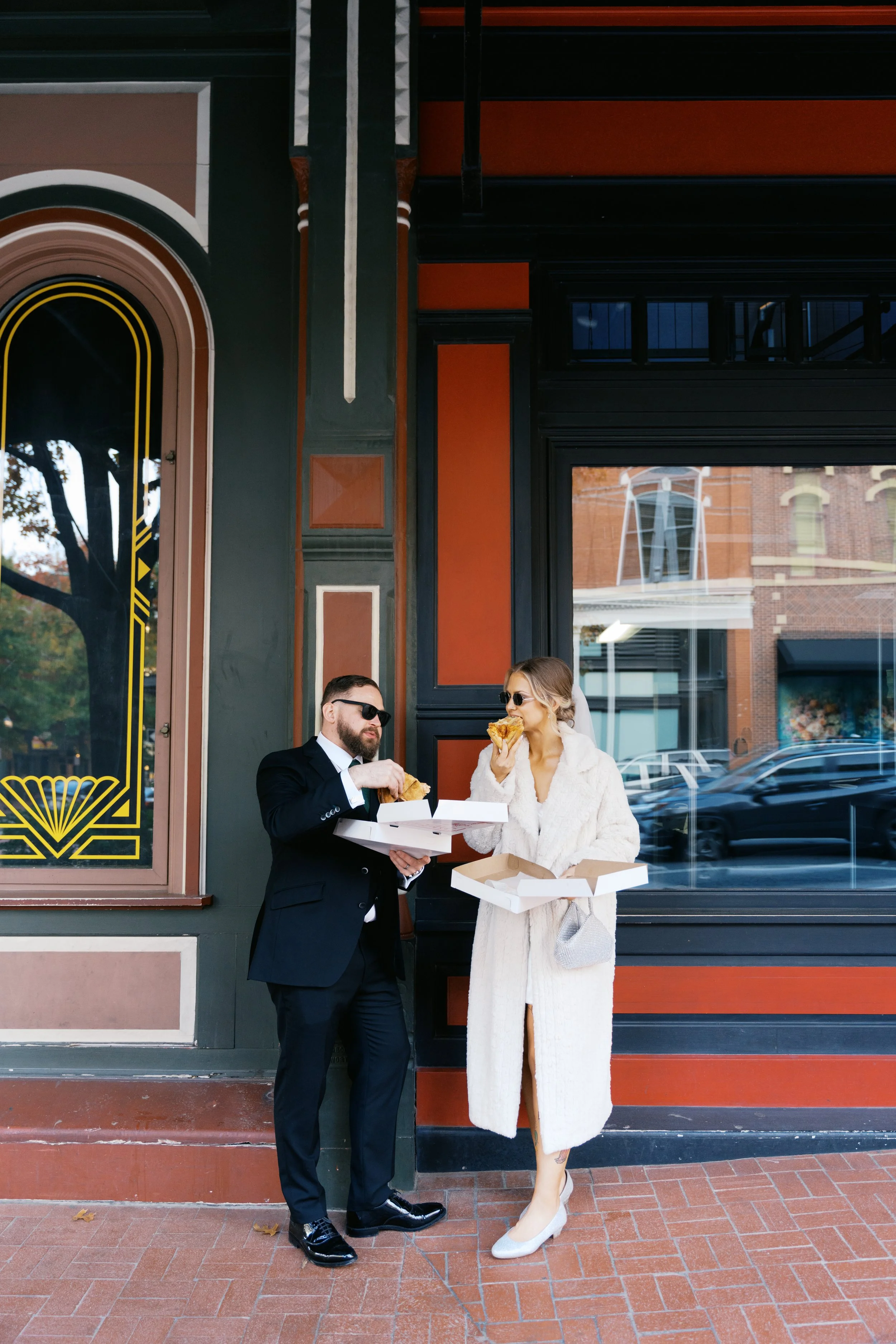 Newly married couple eating pizza outside restaurant in downtown Fort Worth