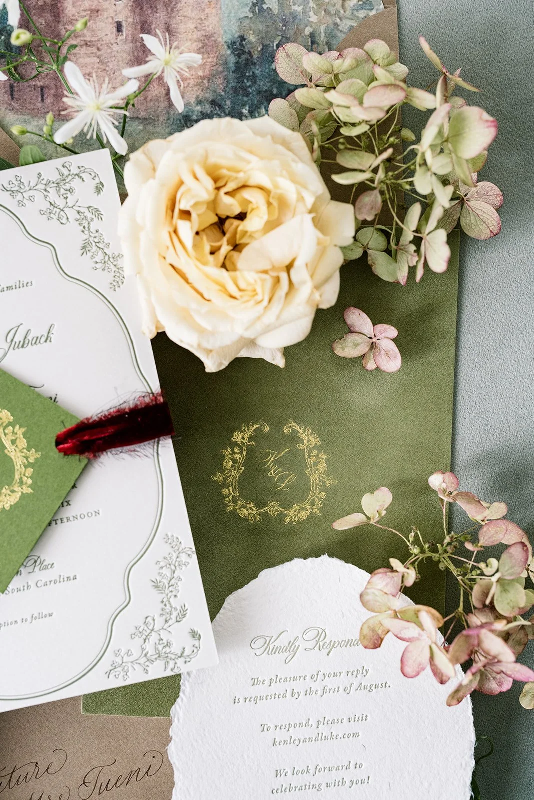 A floral letterpressed wedding invitation suite with white and blush roses, greenery, and elegant black and gold foil details for a Scotland-inspired wedding.