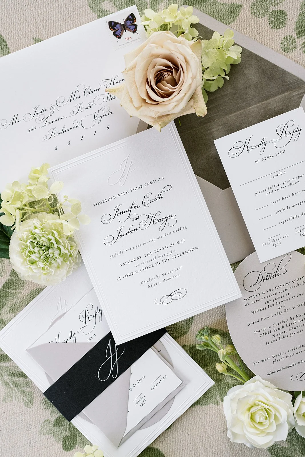 Elegant wedding invitation suite with flowers and a stamp with a butterfly, featuring white, black, and pastel accents.