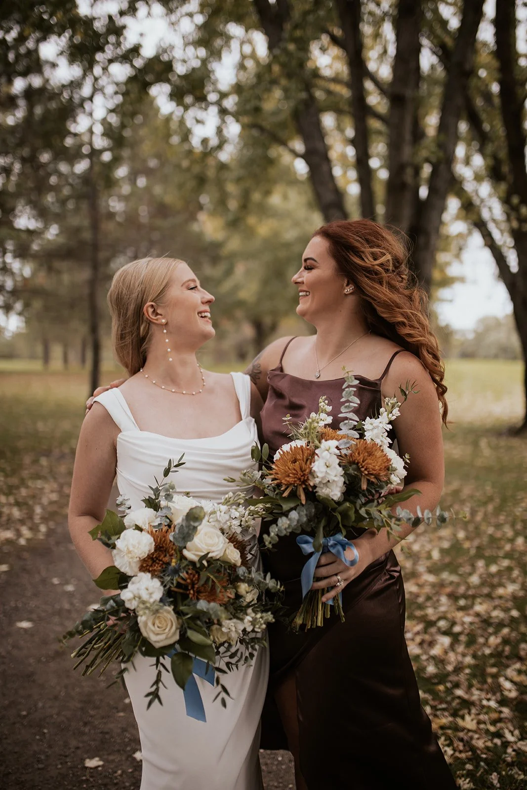 Bride and bridesmaid wearing chocolate dress with fall wedding bouquet