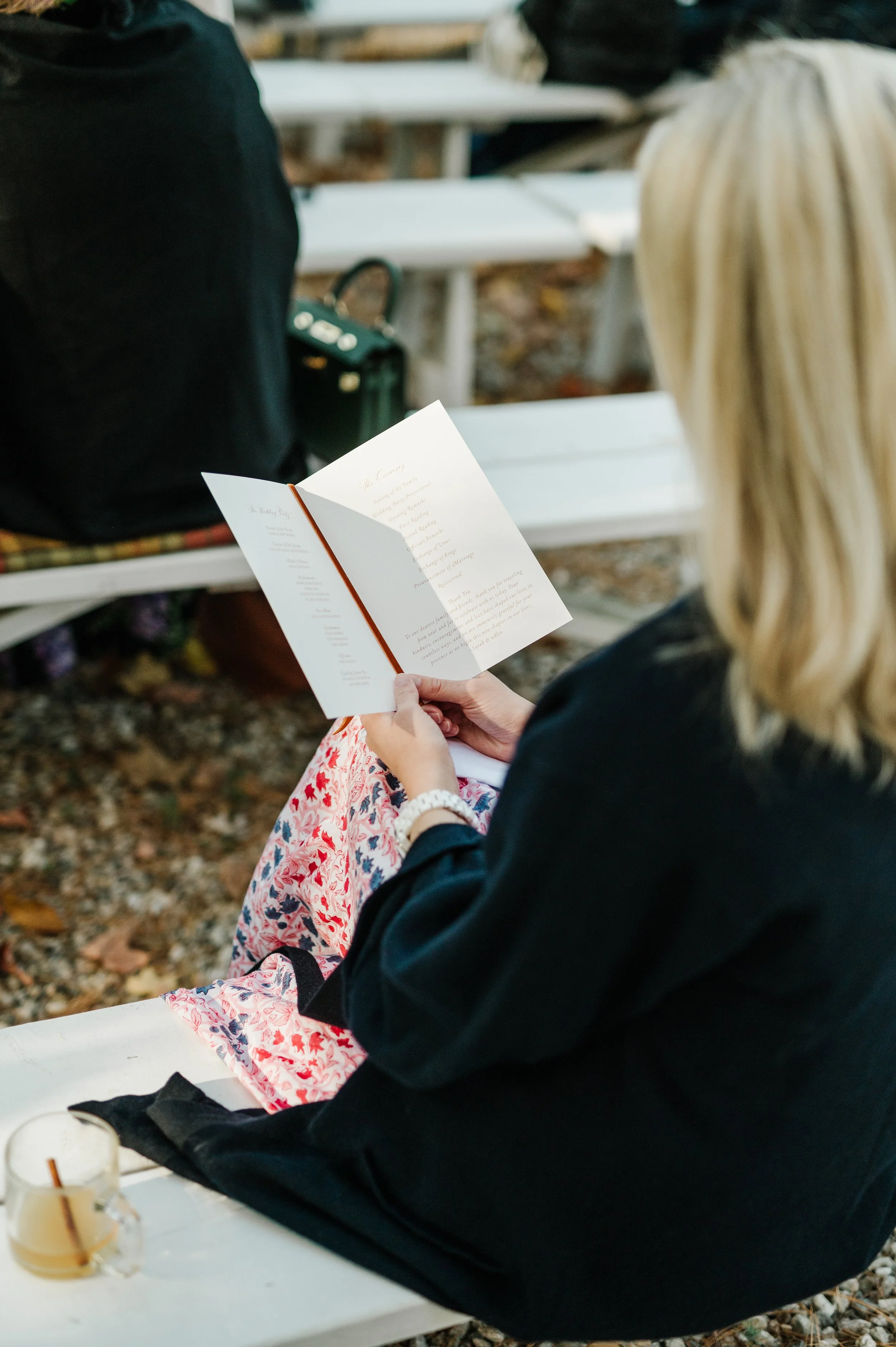 Guest reading custom wedding program at New England fall wedding