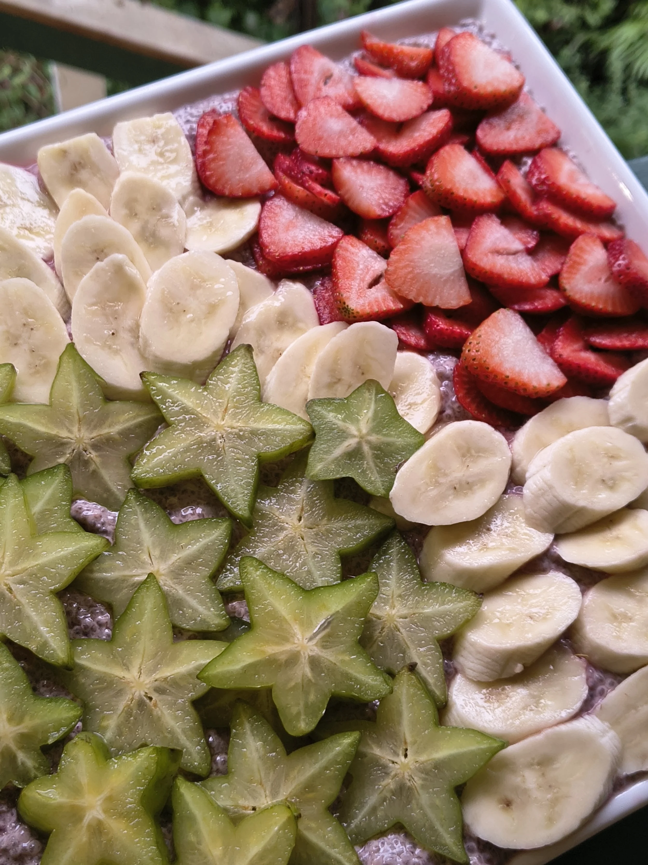 Close-up of a fruit platter with sliced strawberries, bananas, starfruit, and kiwifruit.