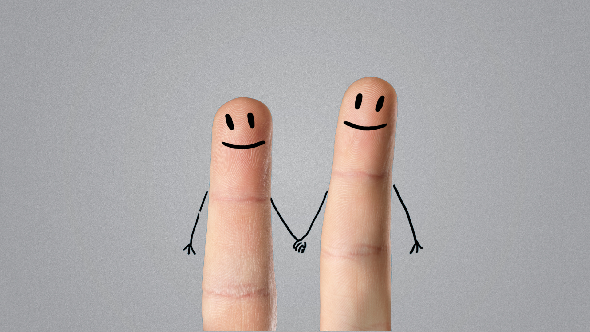 Two fingers with drawn faces, arms, and hands holding each other, creating a cartoon couple.