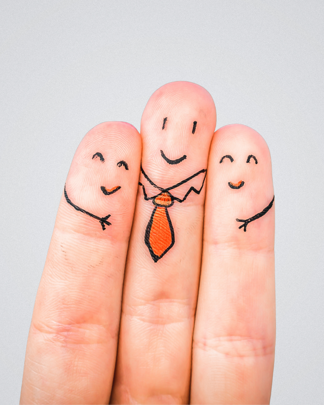 Three fingers with faces and arms drawn on them, each smiling and holding hands. The middle finger has a tie and a collar, resembling a person in a business suit.