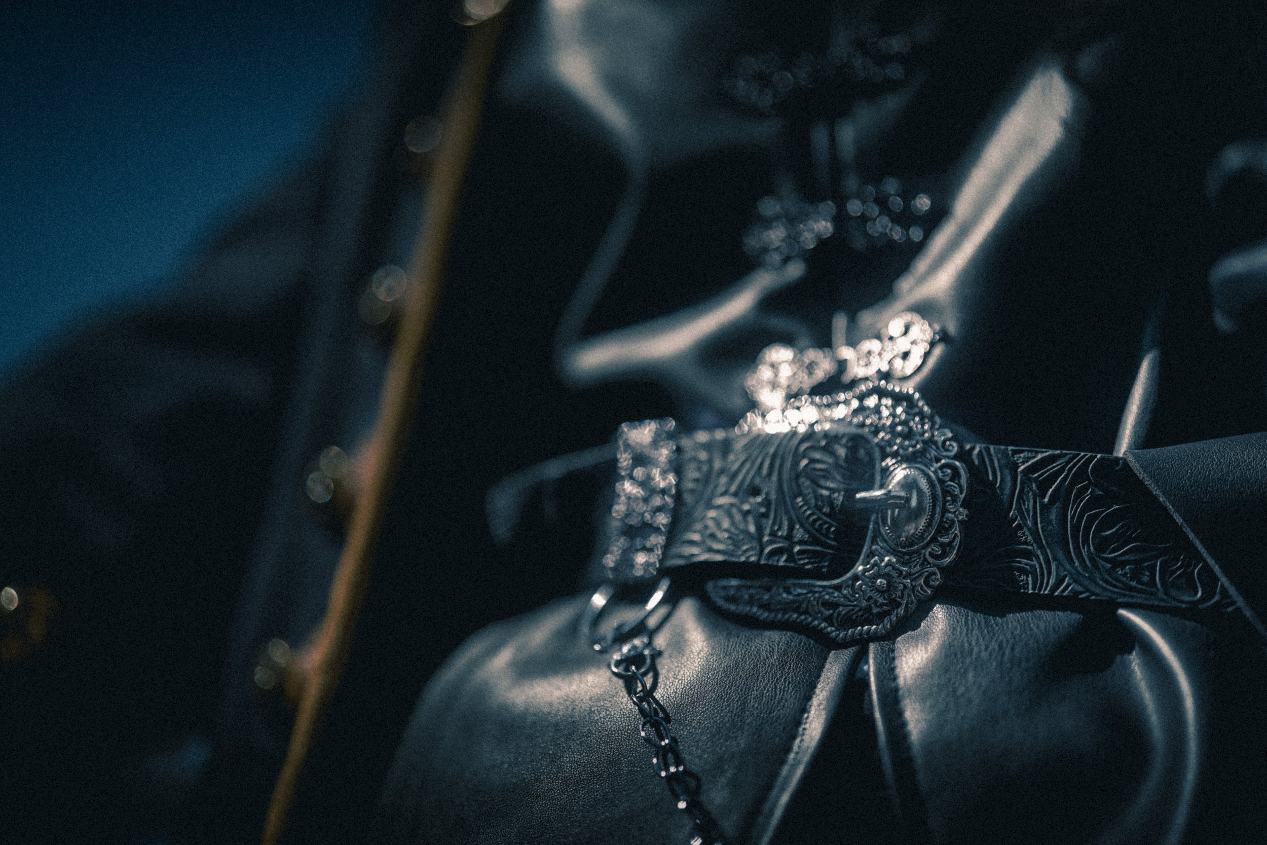 Une montre en argent avec un bracelet en chaîne, placée sur une surface sombre.