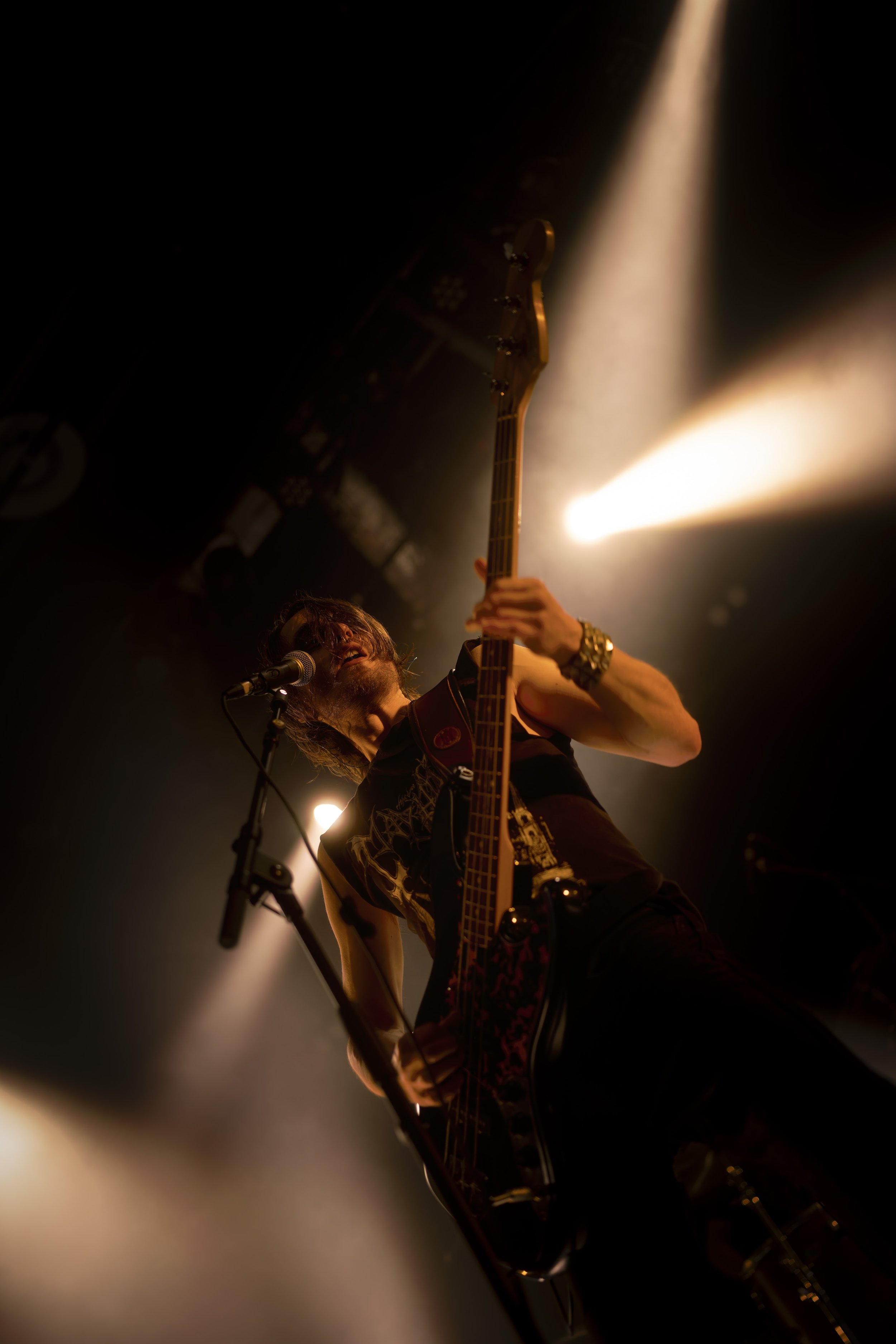 Musicien jouant de la guitare électrique sur scène avec éclairage dramatique