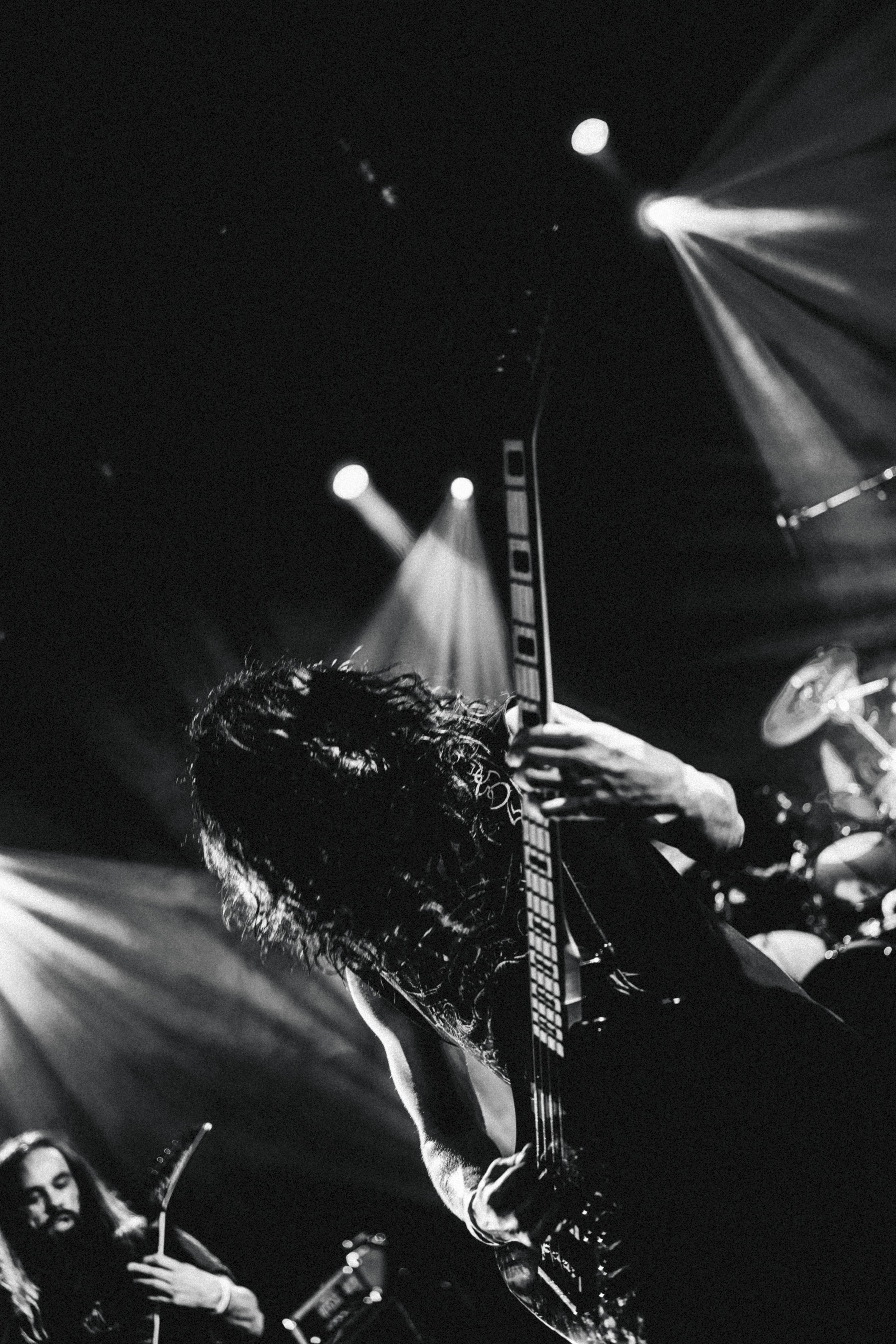 Musicien jouant de la guitare électrique lors d'un concert, éclairage en scène.