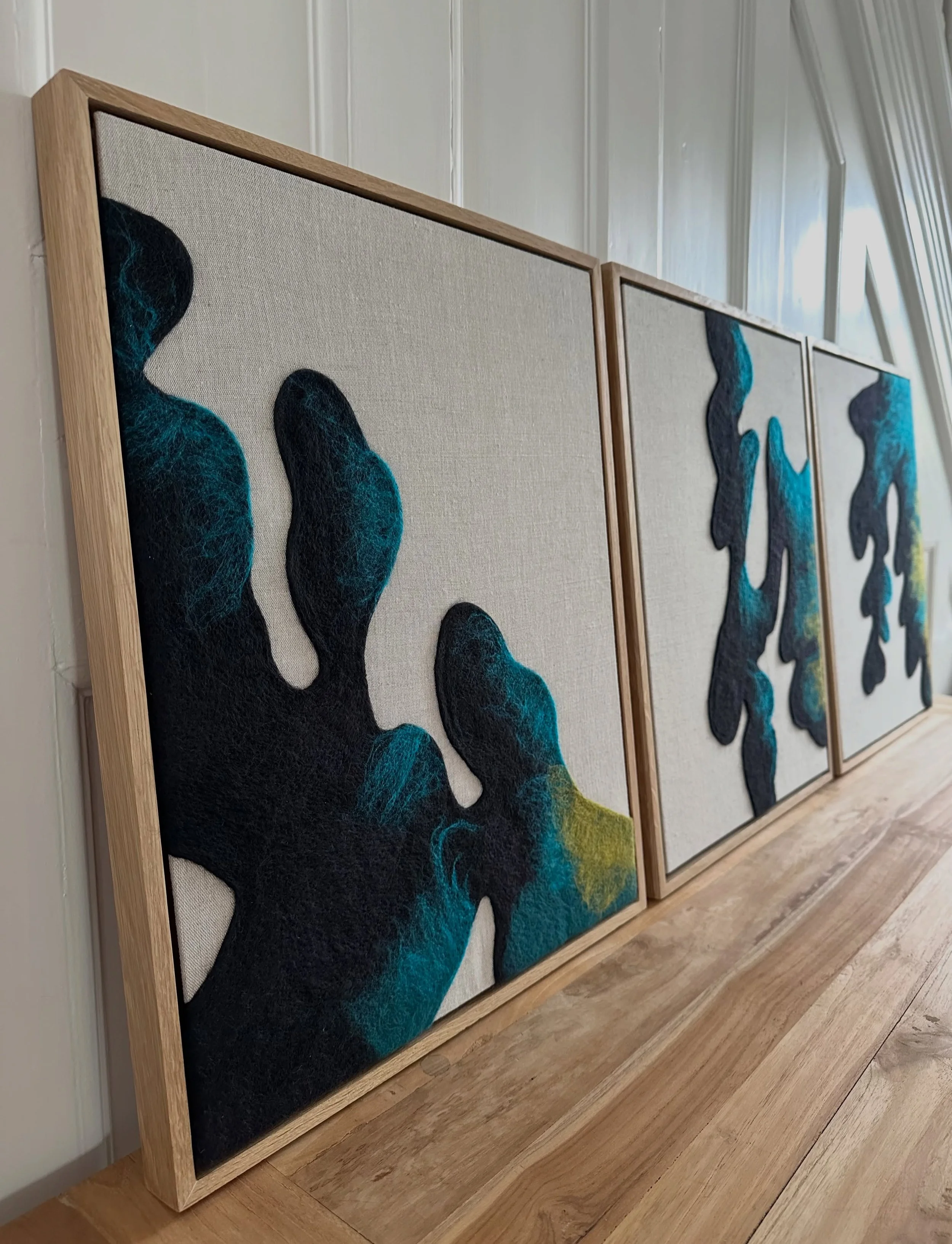 Distant Shore Triptych

Painterly fibres flow to the edges of the pieces, evoking deep waters, ocean currents and tidal movement. Created from layers of merino wool needle-felted onto linen, using wool fibres much like paint, each piece is led by the