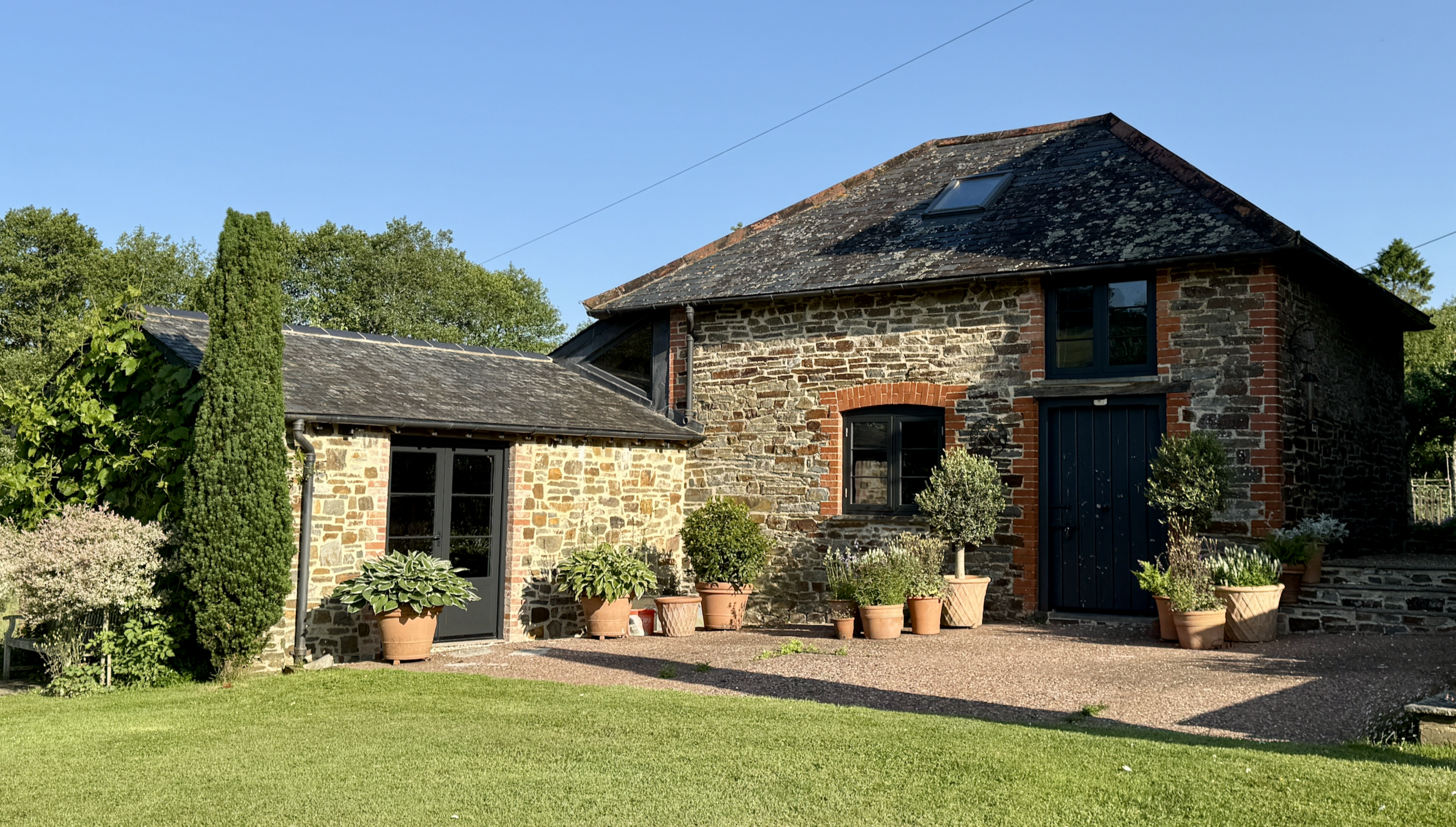 An image of Jenny Nash's riverside art studio - local stone walls under a traditional slate roof