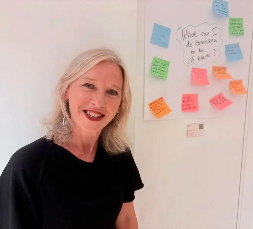 Pauline standing with a wall of post-it notes behind