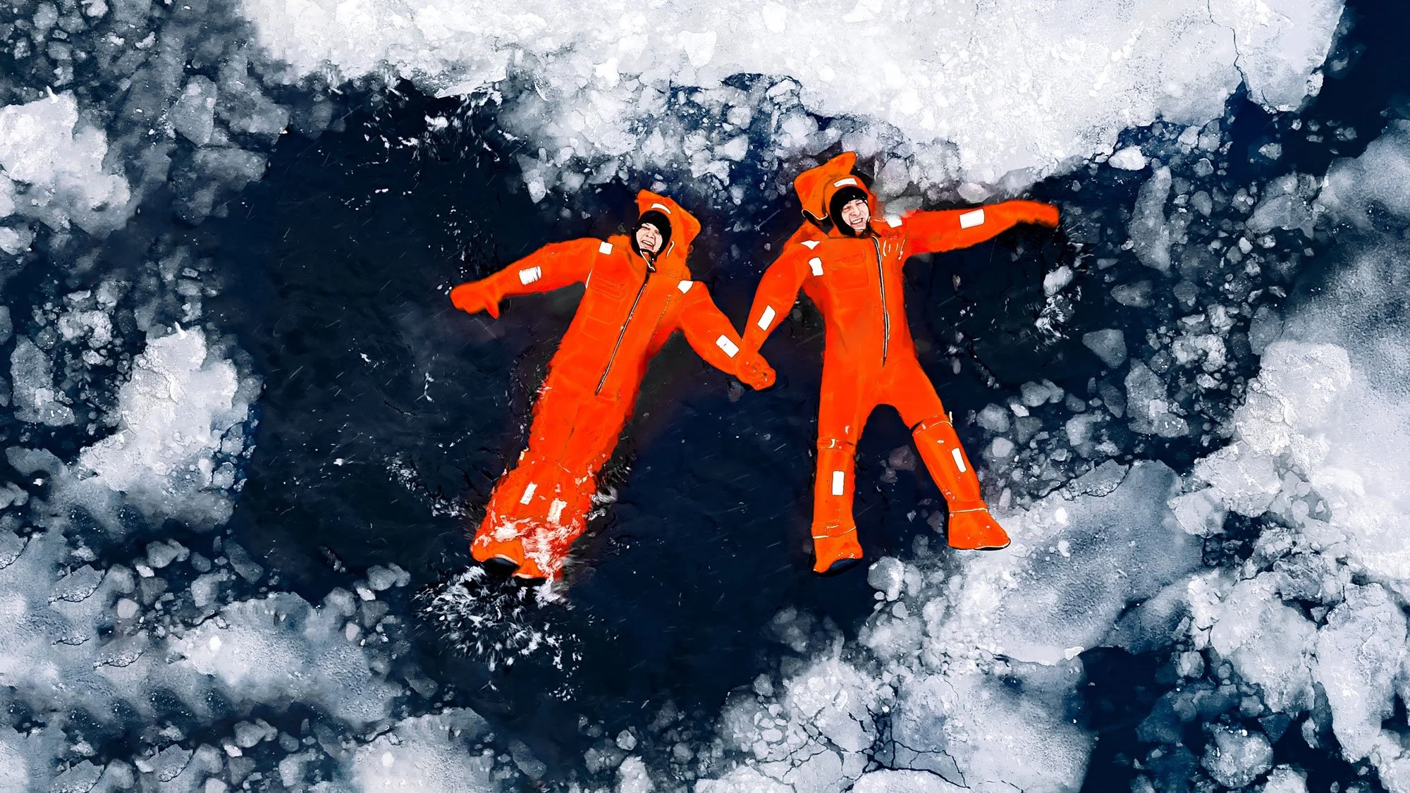 Fearless individuals in ice suits floating in the ocean surrounded by ice.