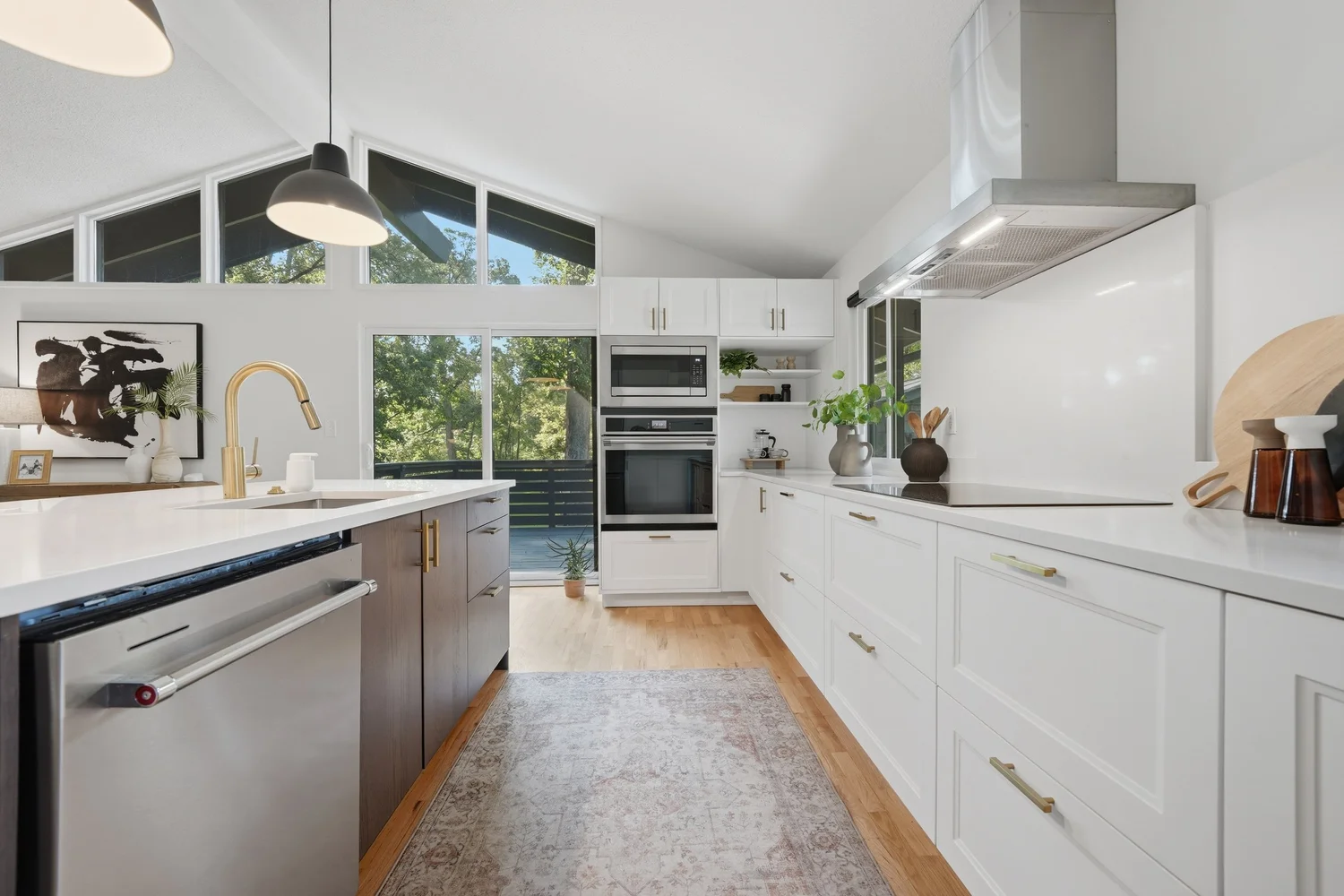 Bright white kitchen with a vaulted ceiling and wooded view