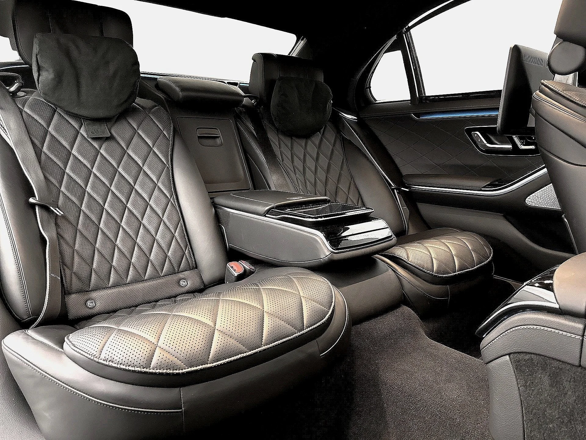 Luxury car interior with quilted leather seats, headrests, and center console.