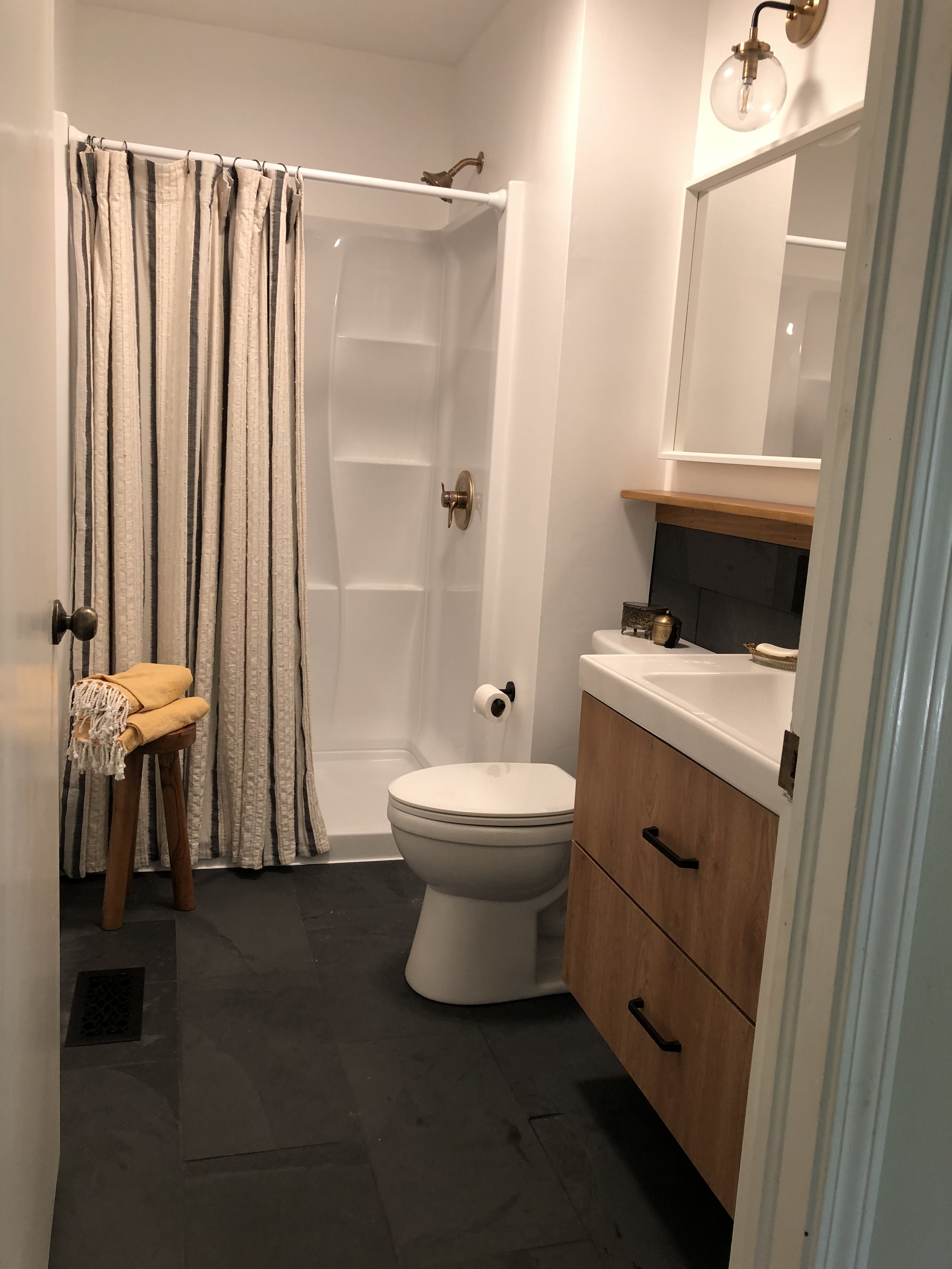 Large format natural slate floor and wainscoting. Fiberglass shower and associated plumbing fixtures installed.
