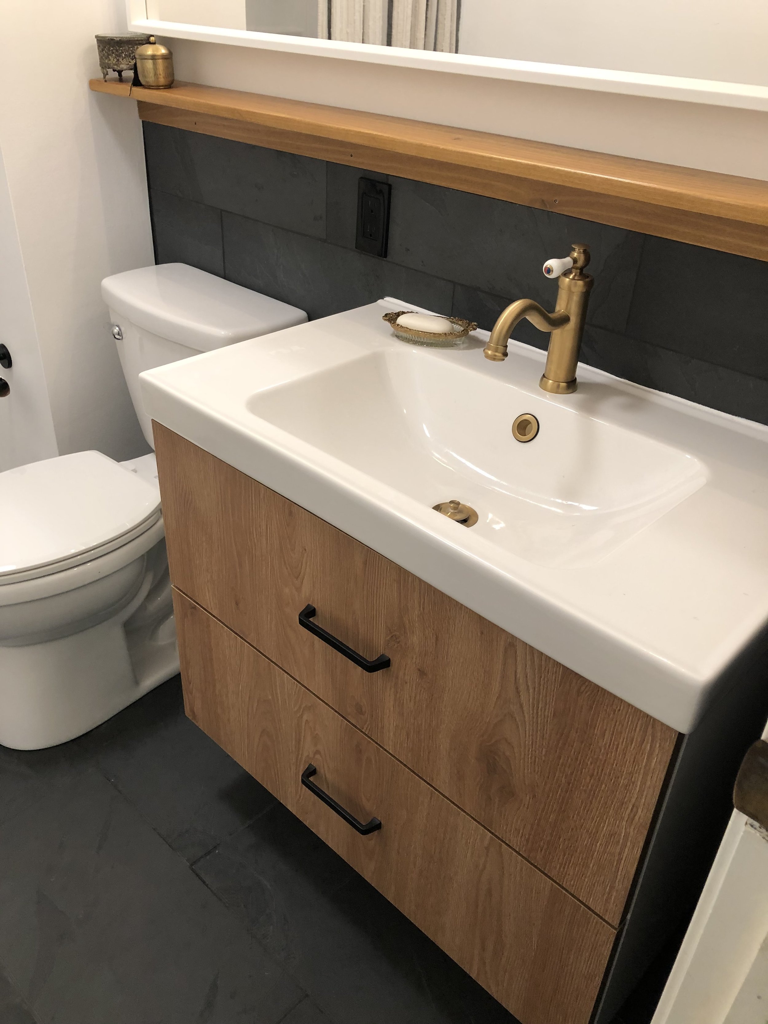 Large format natural slate floor and wainscoting. New vanity installation. Custom shelf construction and installation.