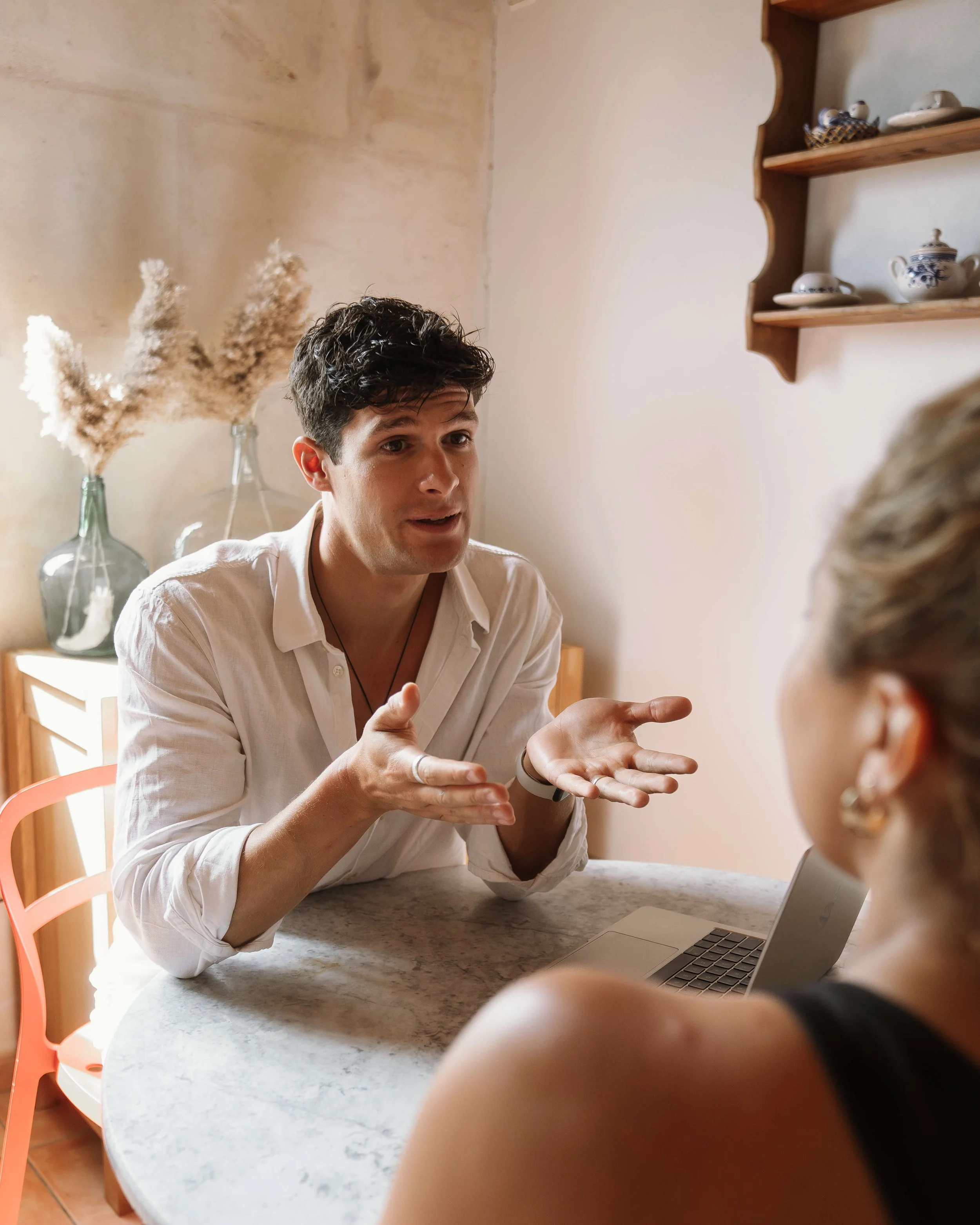 Man in white shirt discussing with woman at round table