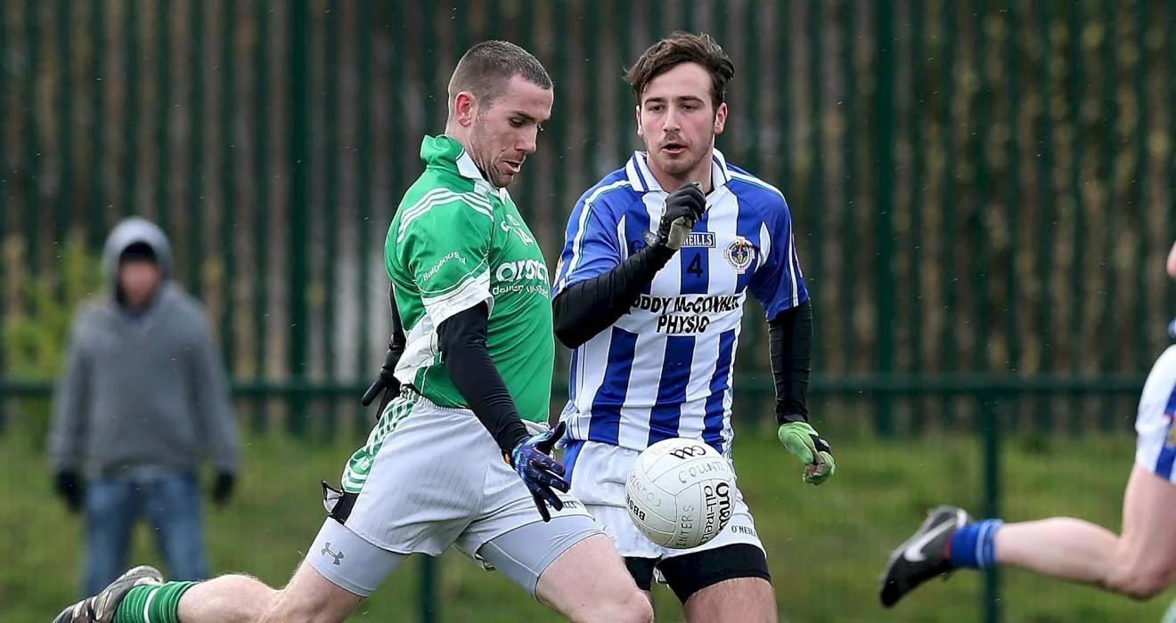 Two male soccer players competing for the ball during a game, one in a green jersey and the other in a blue and white striped jersey.