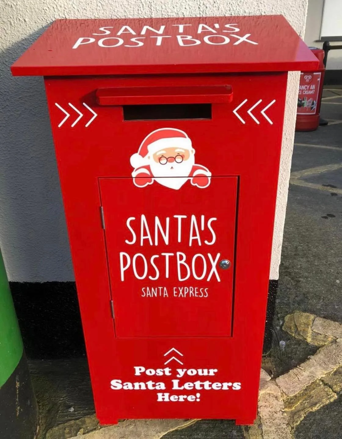 Red Santa-themed mailbox with a cartoon Santa face and the words "Santa's Postbox" and "Post your Santa Letters Here!"