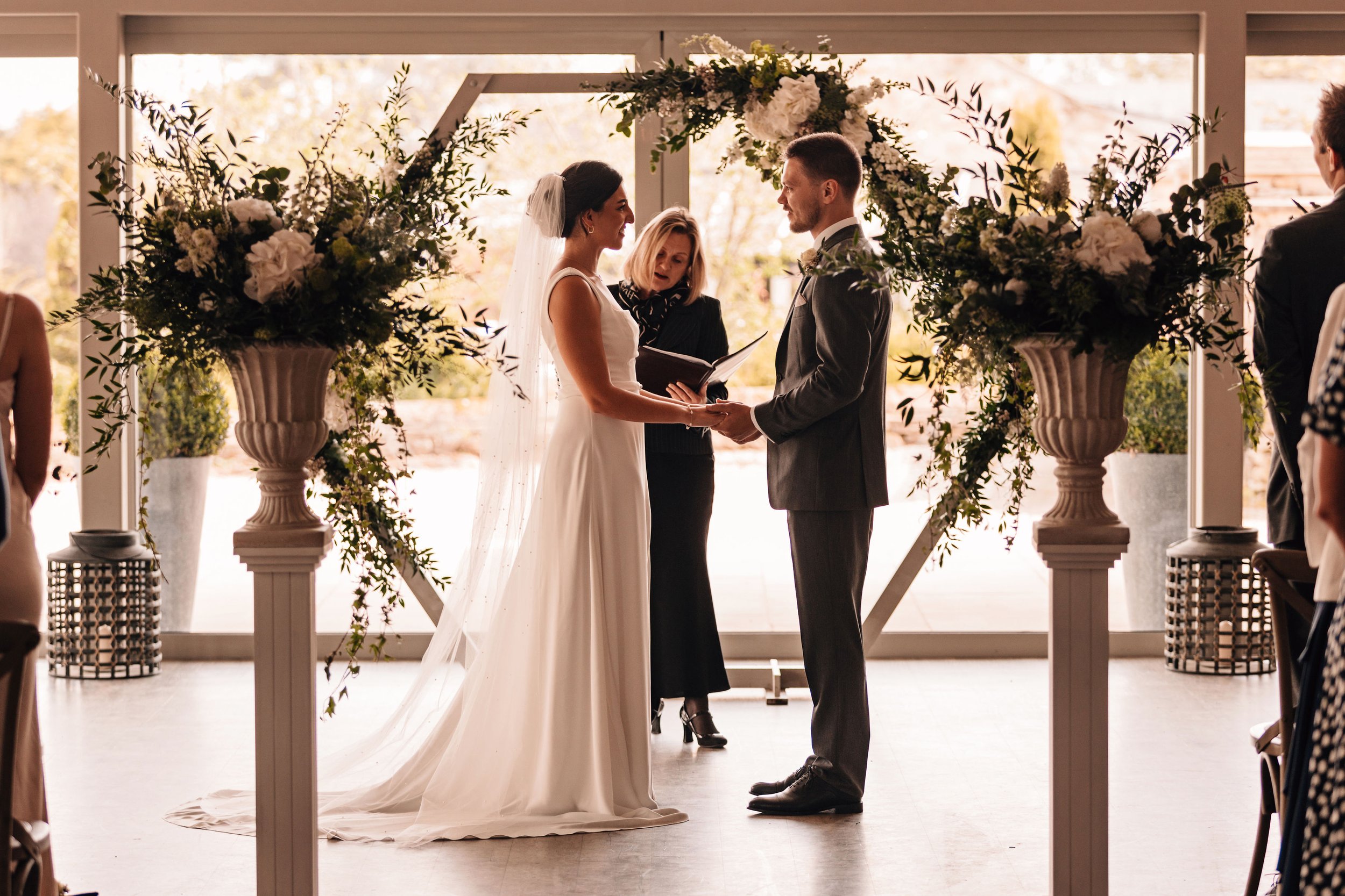 Wedding arch and floral urns to frame the ceremony space