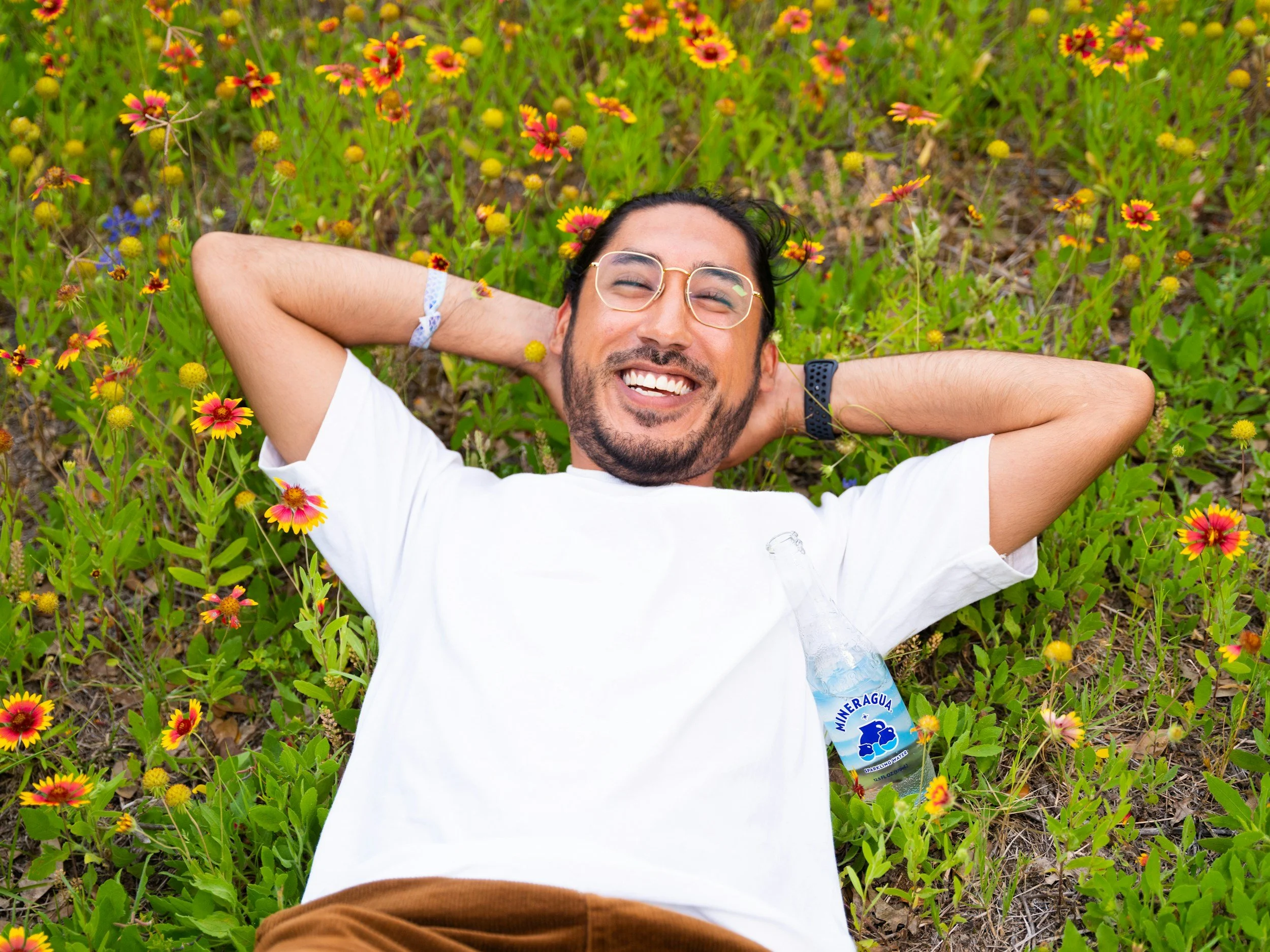 smiling man reclined around flowers | Feeling more at ease when exploring support for chronic pain