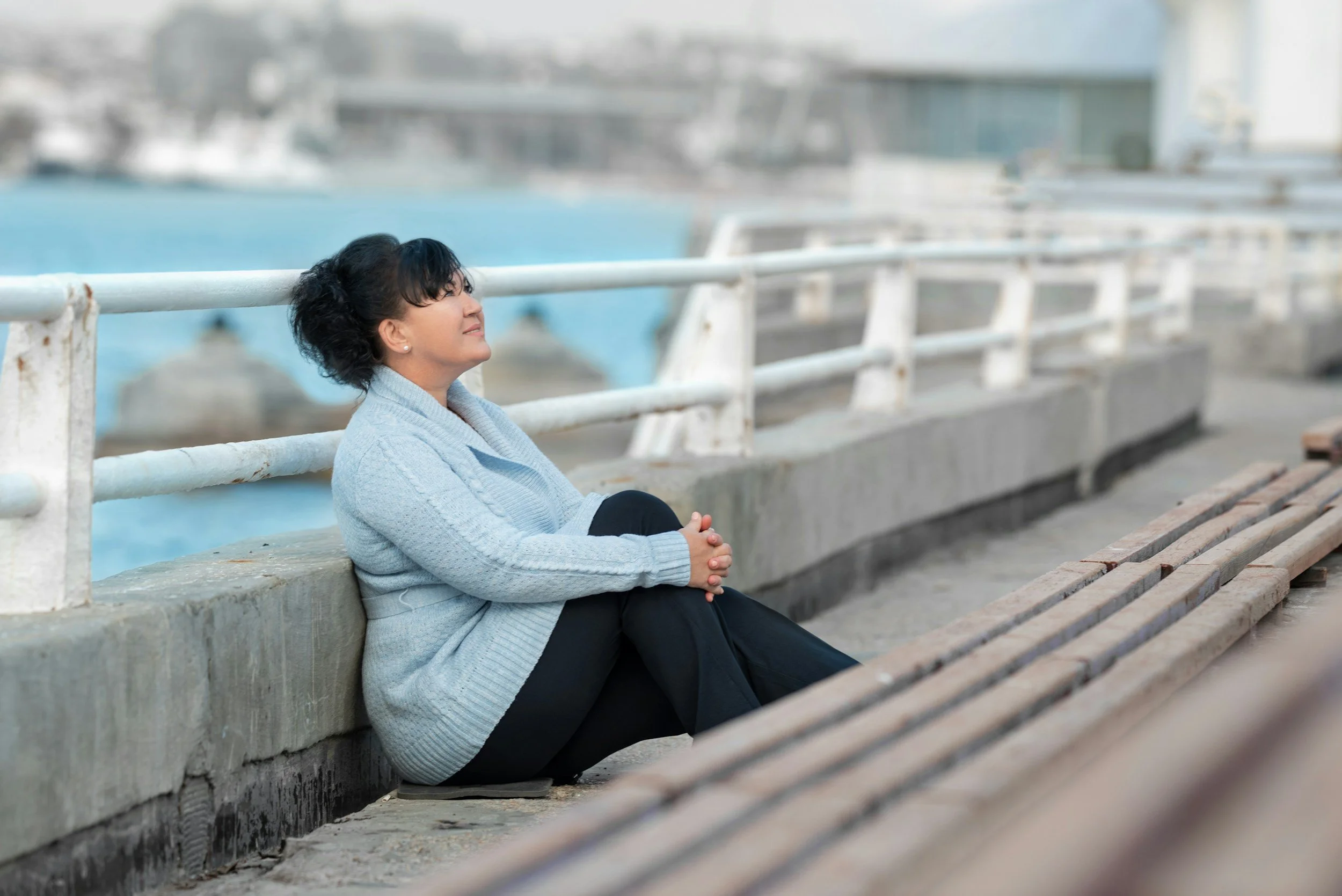 woman on bridge looking at ease | Chronic pain is real even when stress plays a role