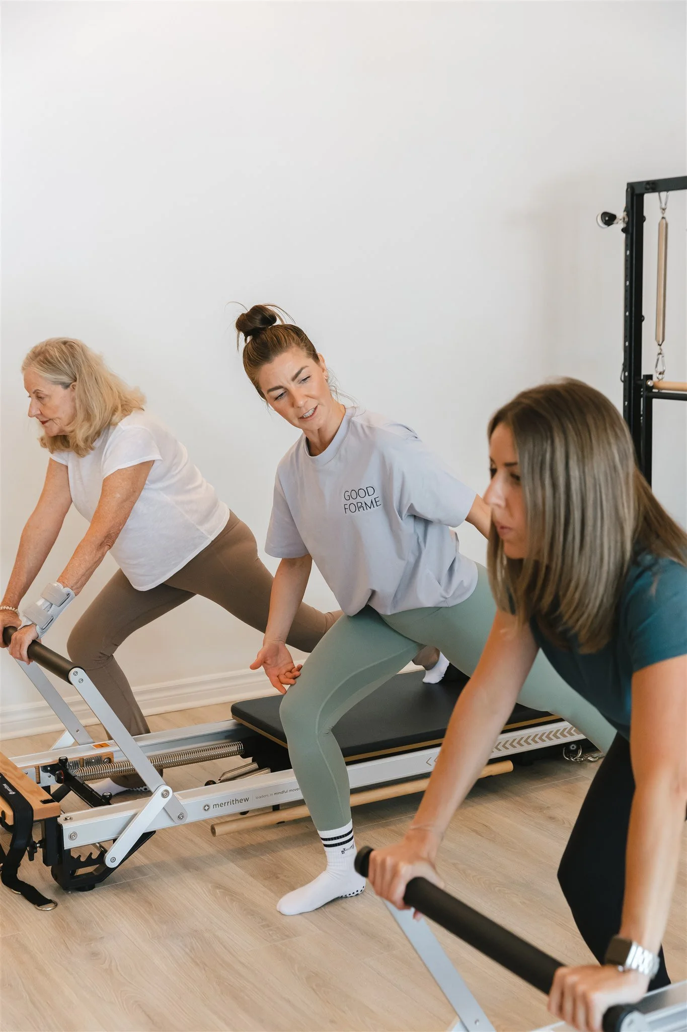 Pilates Process instructor instructing female clients on Reformer