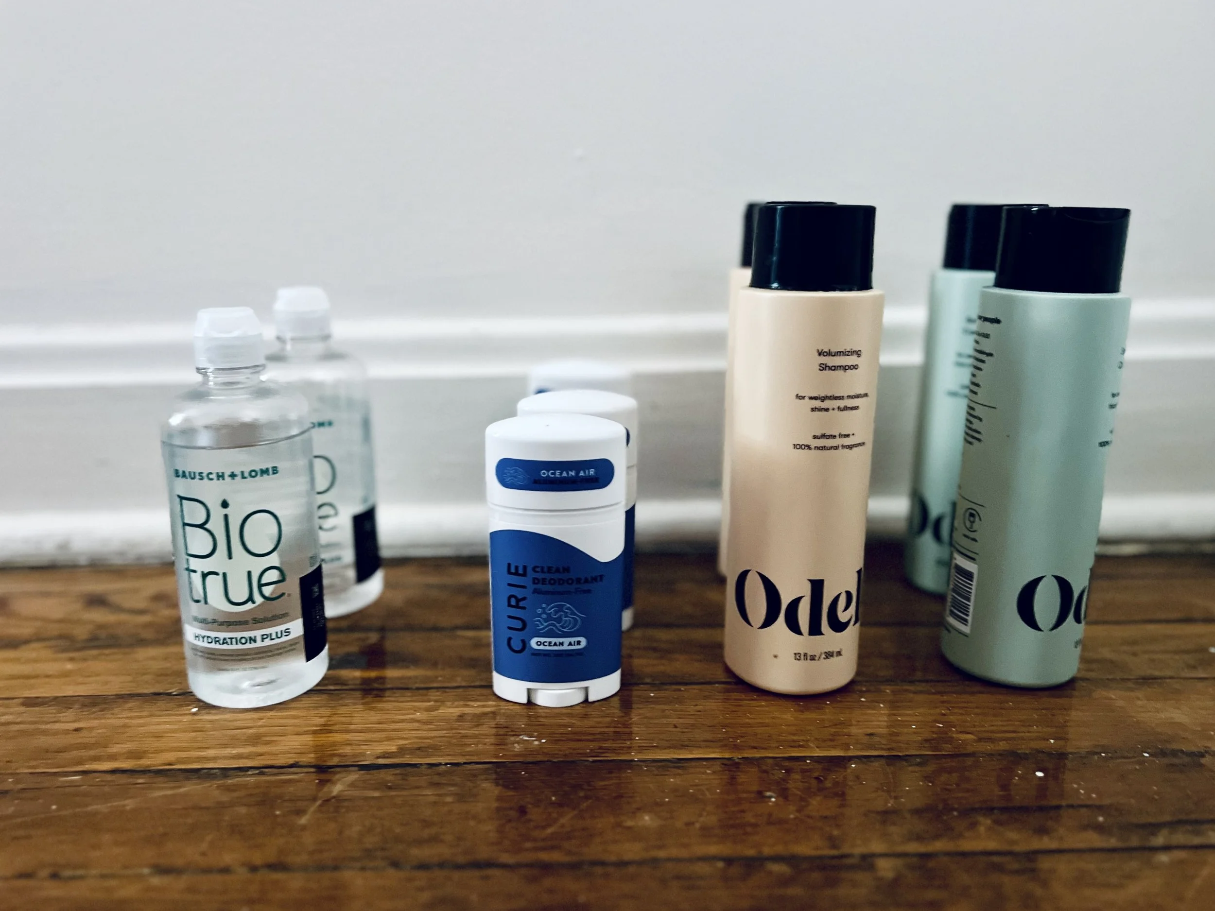 row of shampoo, deodorant and contact solution bottles