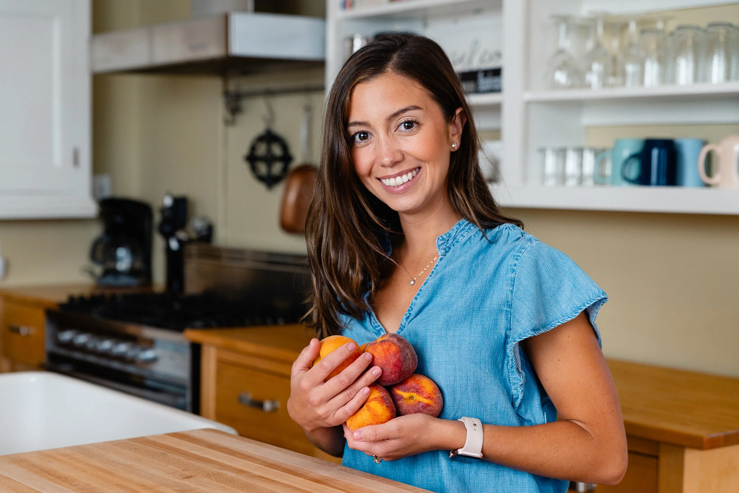 photo of Nikita Grove holding peaches