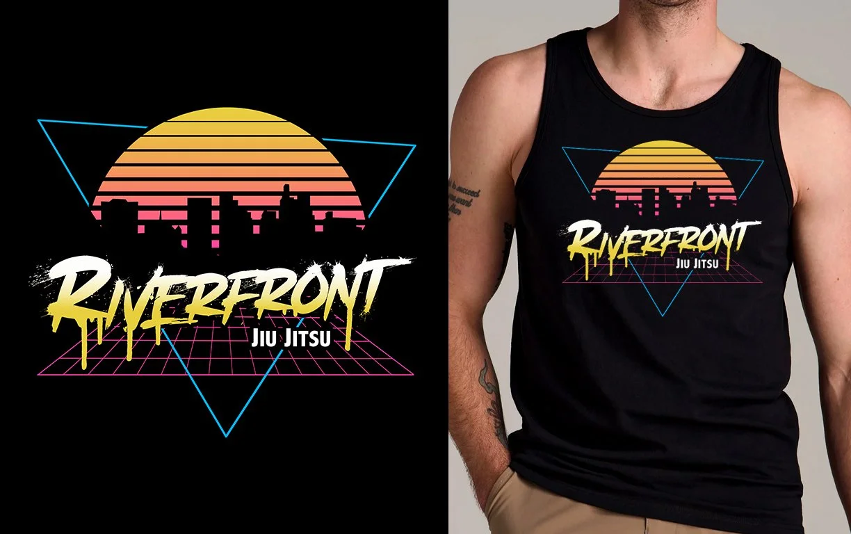 Tank top with retro design featuring a city silhouette, sunset, and the text 'Riverfront Jiu Jitsu'.