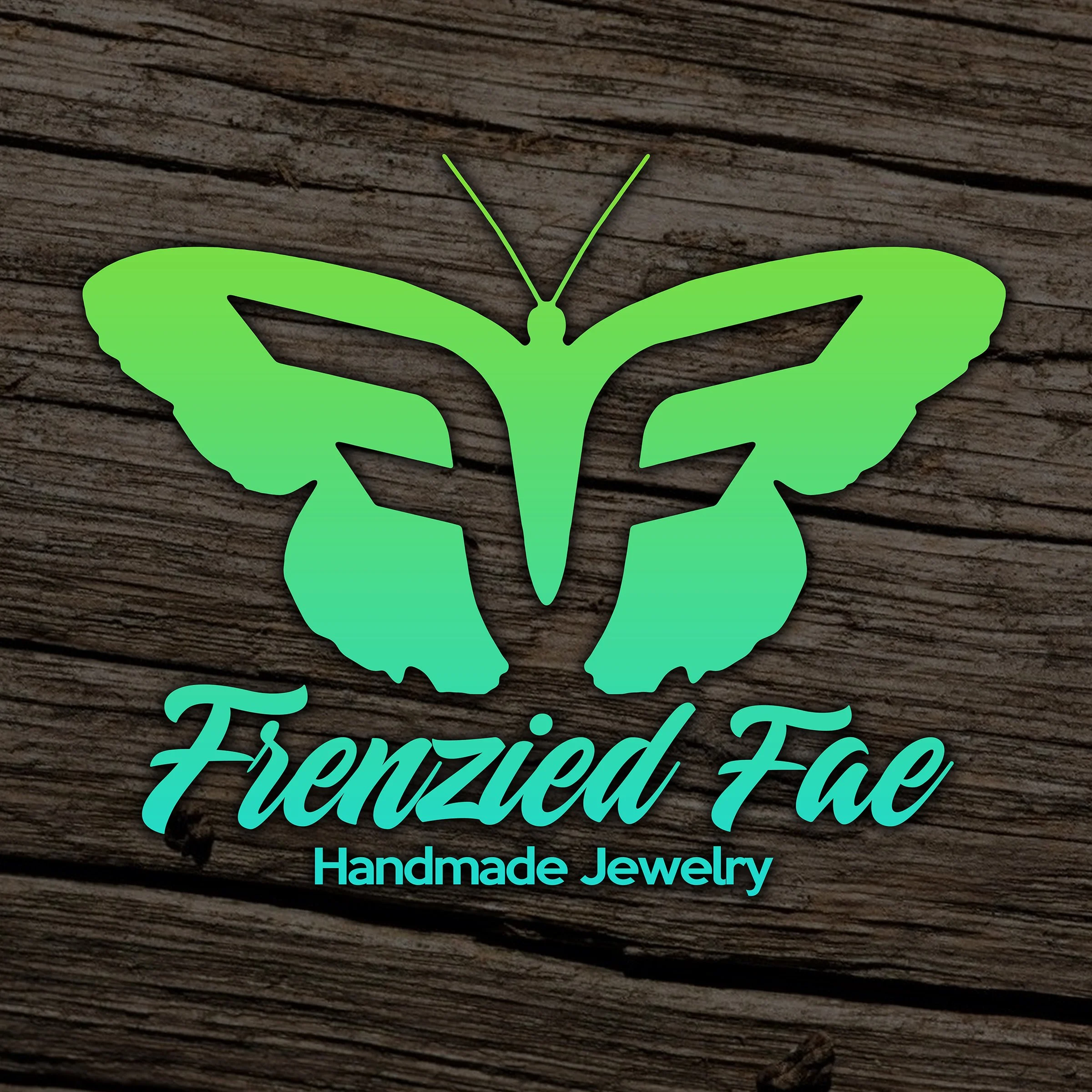 Green butterfly logo of Frenzied Fae Handmade Jewelry on a wooden background.