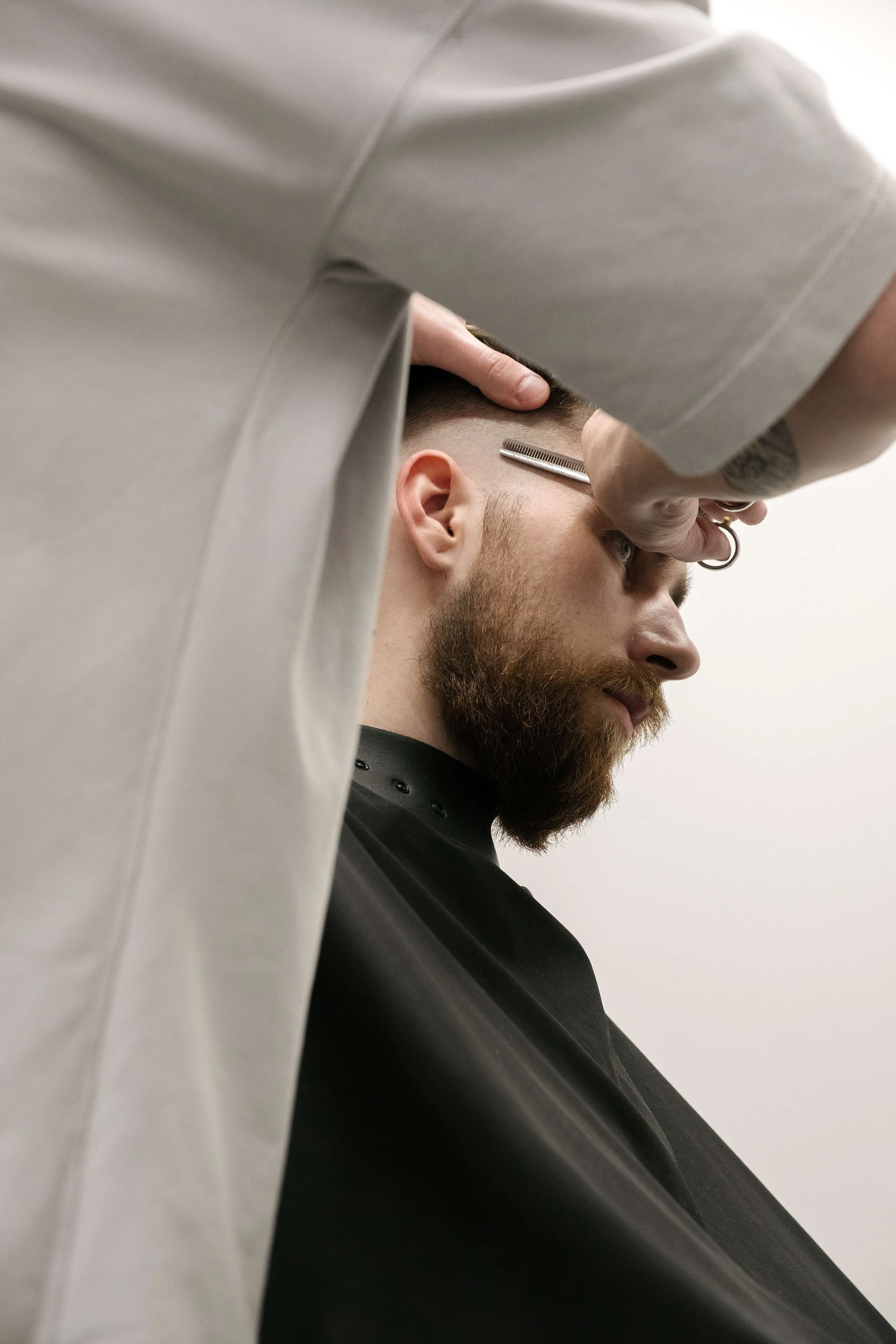 Ein Bild eines Mannes, der sich vom Friseur die Haare schneiden lässt.