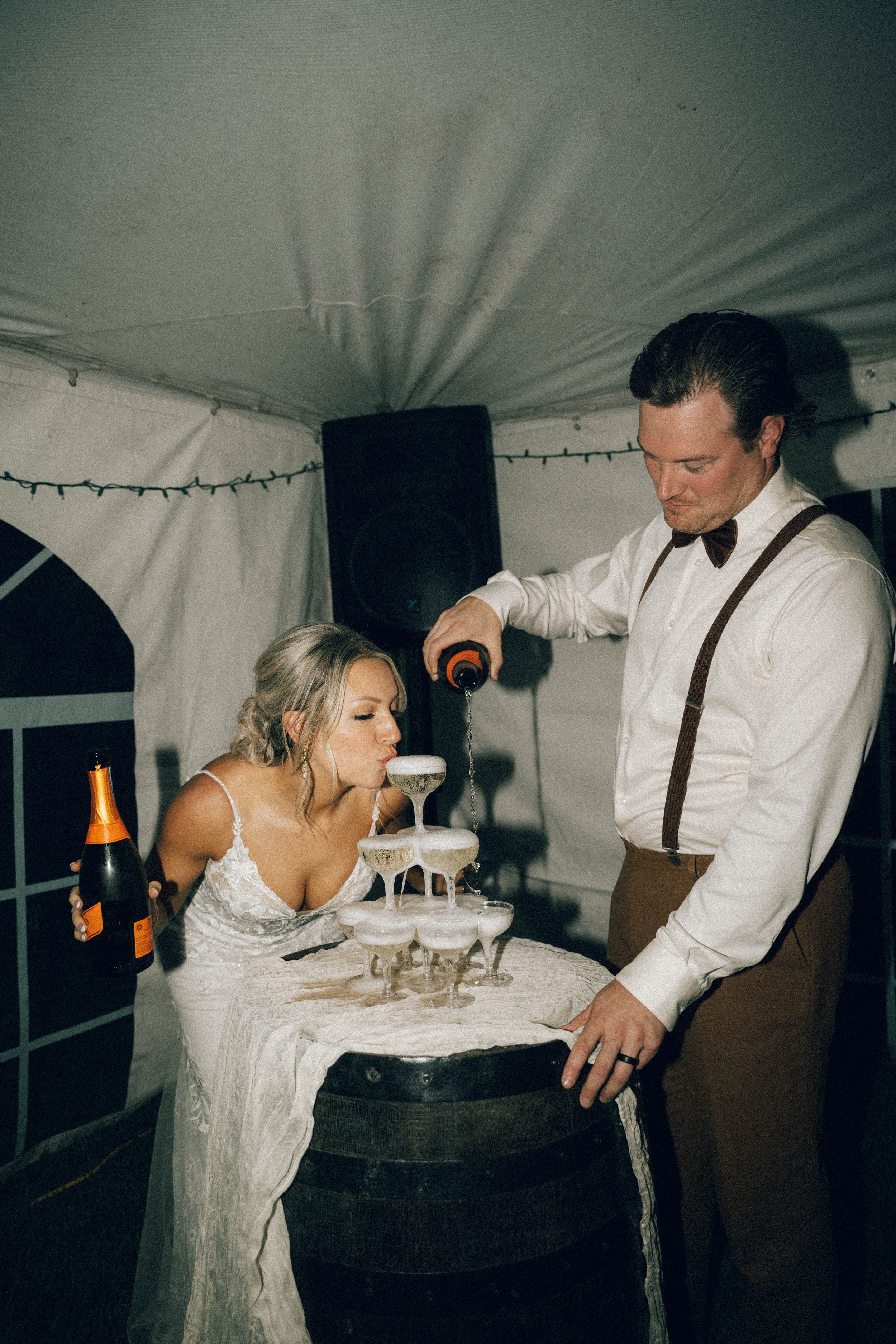 Bride and groom pouring champagne under a tent in Chiliwack, BC
