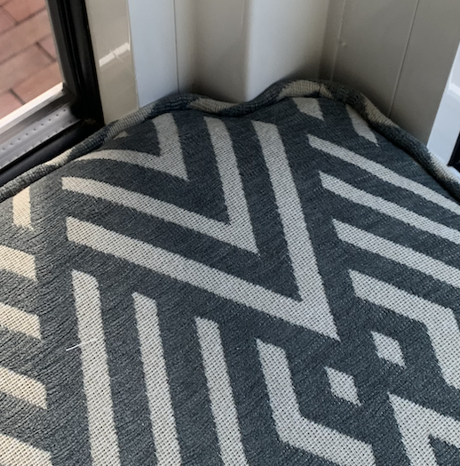 De afbeelding toont een moeilijke hoek voor een maatkussen met een geometrisch zwart-wit patroon, in Amsterdam