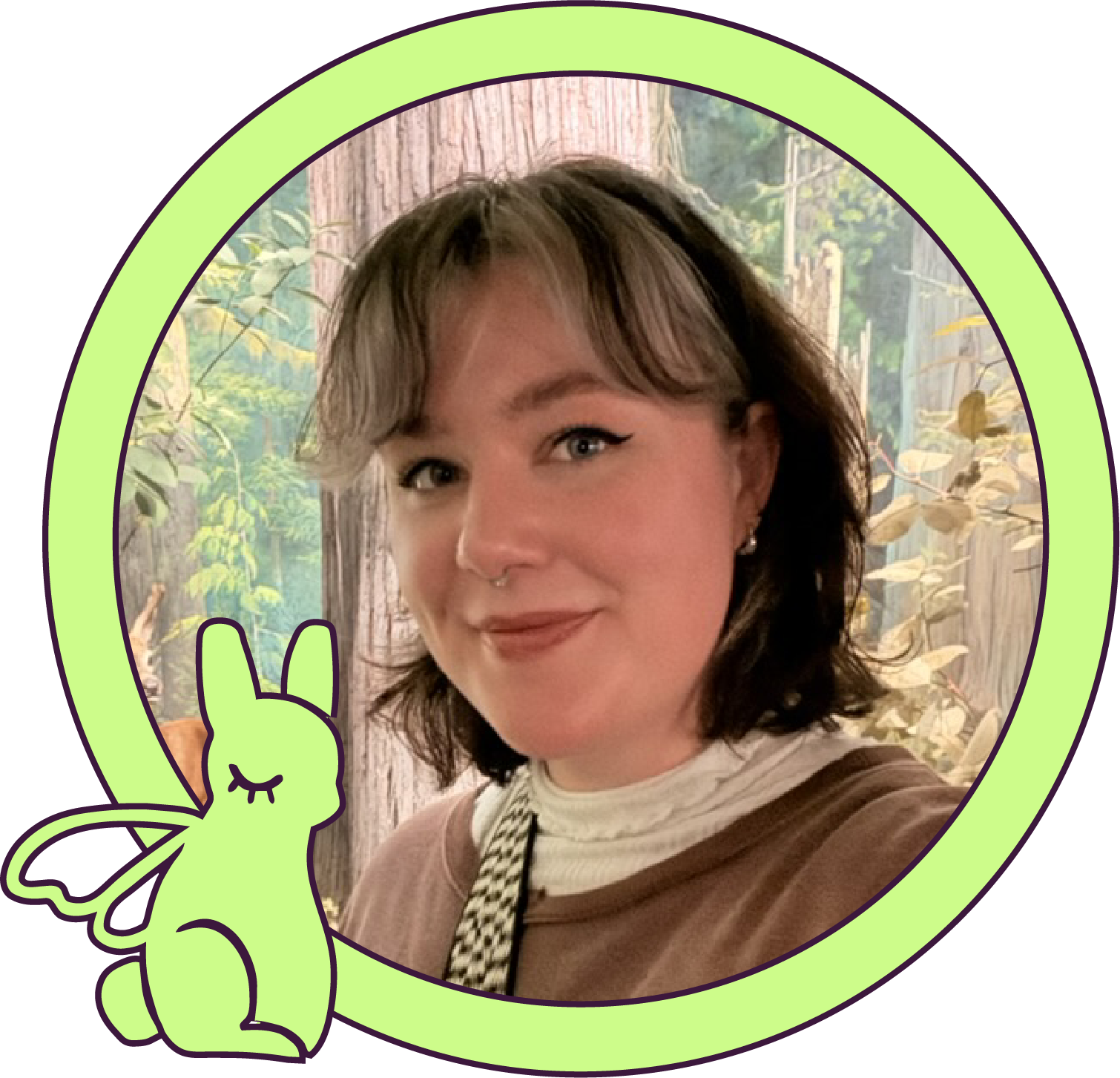 A woman with shoulder-length brown hair, wearing a brown top, smiling, with a forest background, and a neon green bunny illustration on the left.