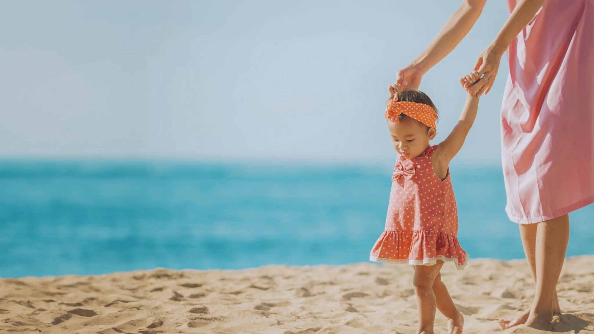 Image of a baby walking on a beach for a homepage talking about fertility treatment at SCCRM in Southern California