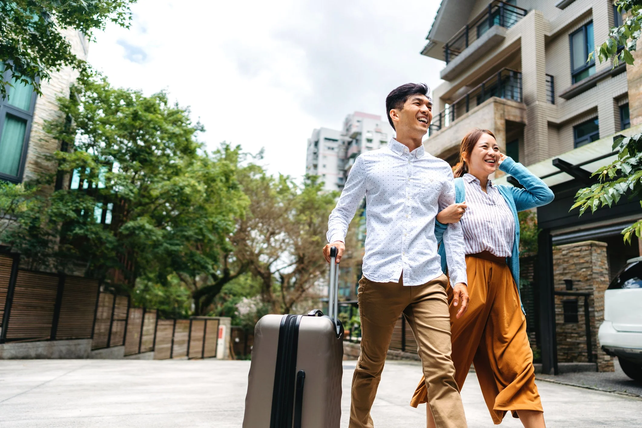Couple walking with suitcase outdoors heading to international fertility care appointment